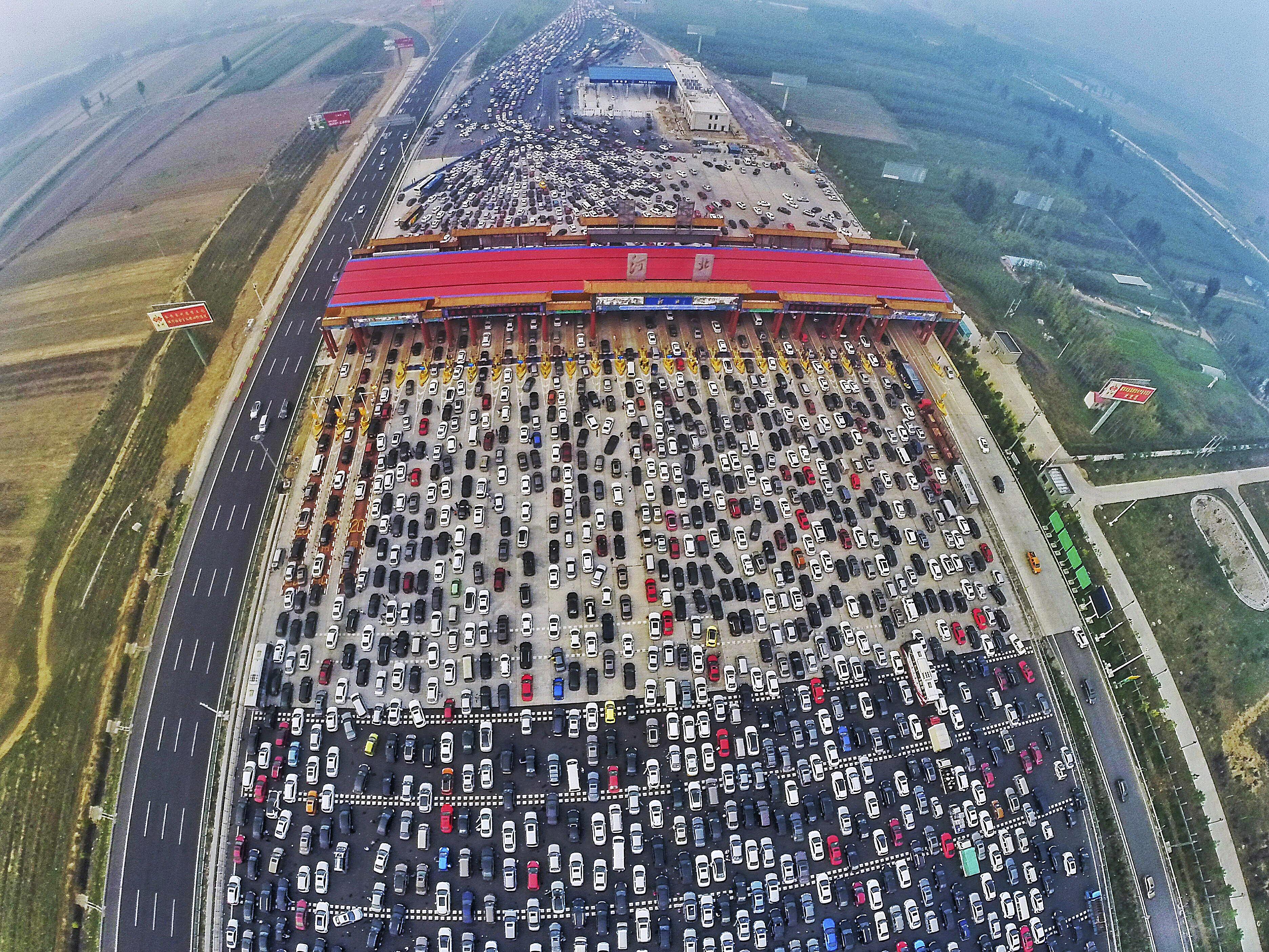 Vehicles are seen stuck in a traffic jam near a toll station as people return home at the end of a w