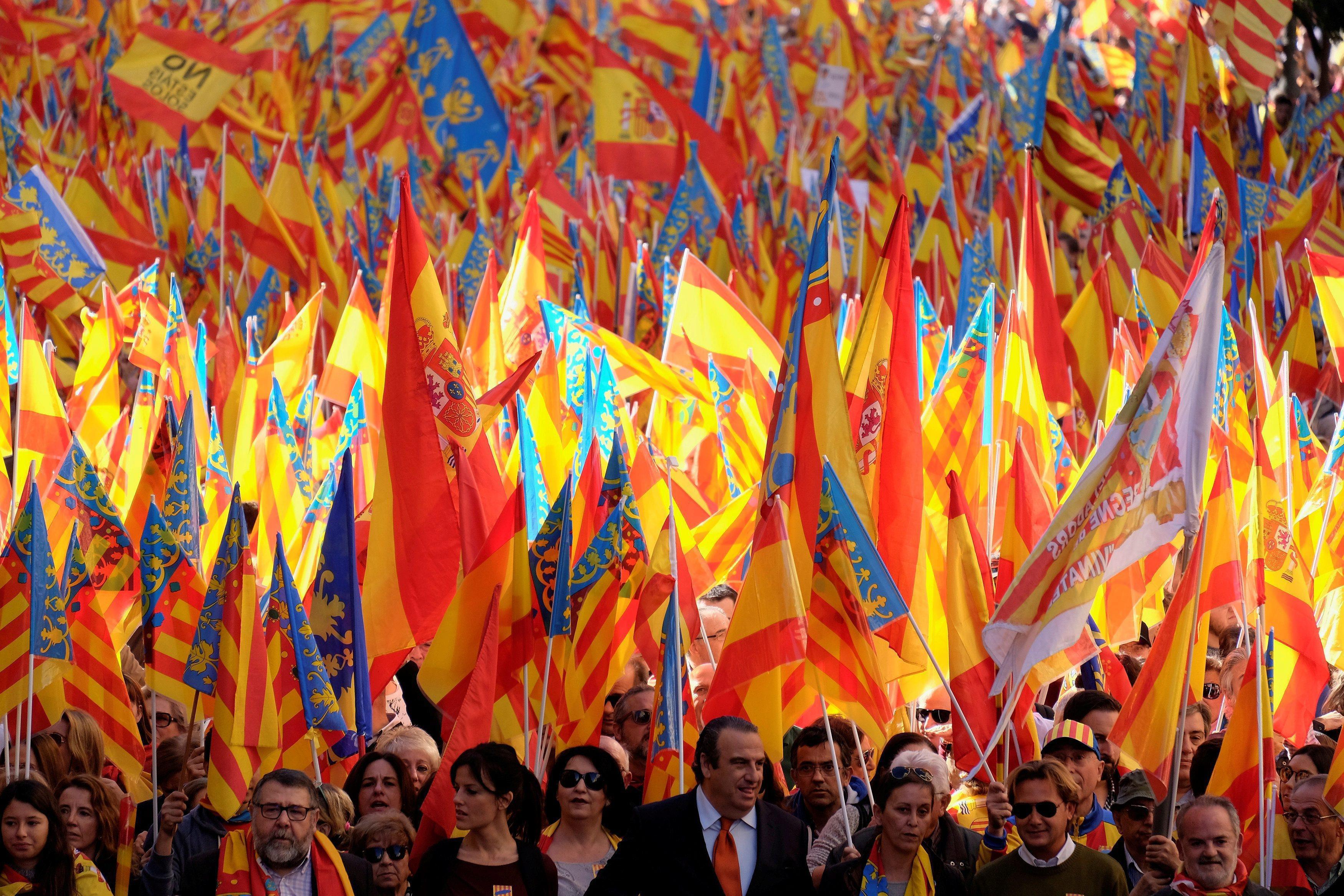 Protesters wave Spanish and Valencian flags during a demonstration in support of the national unity 