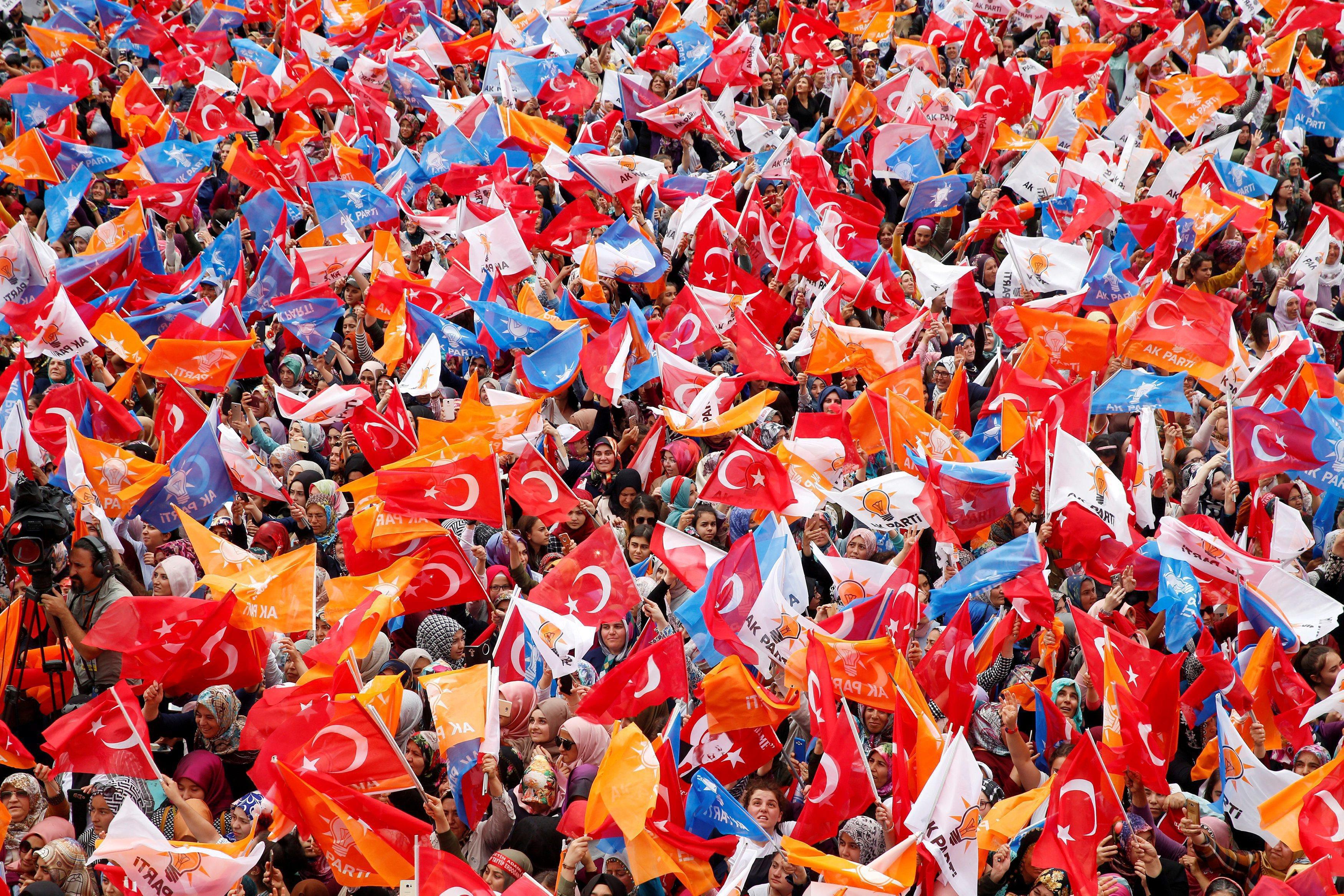 Supporters of Turkish President Erdogan wave Turkish and AK Party flags during an election rally in 