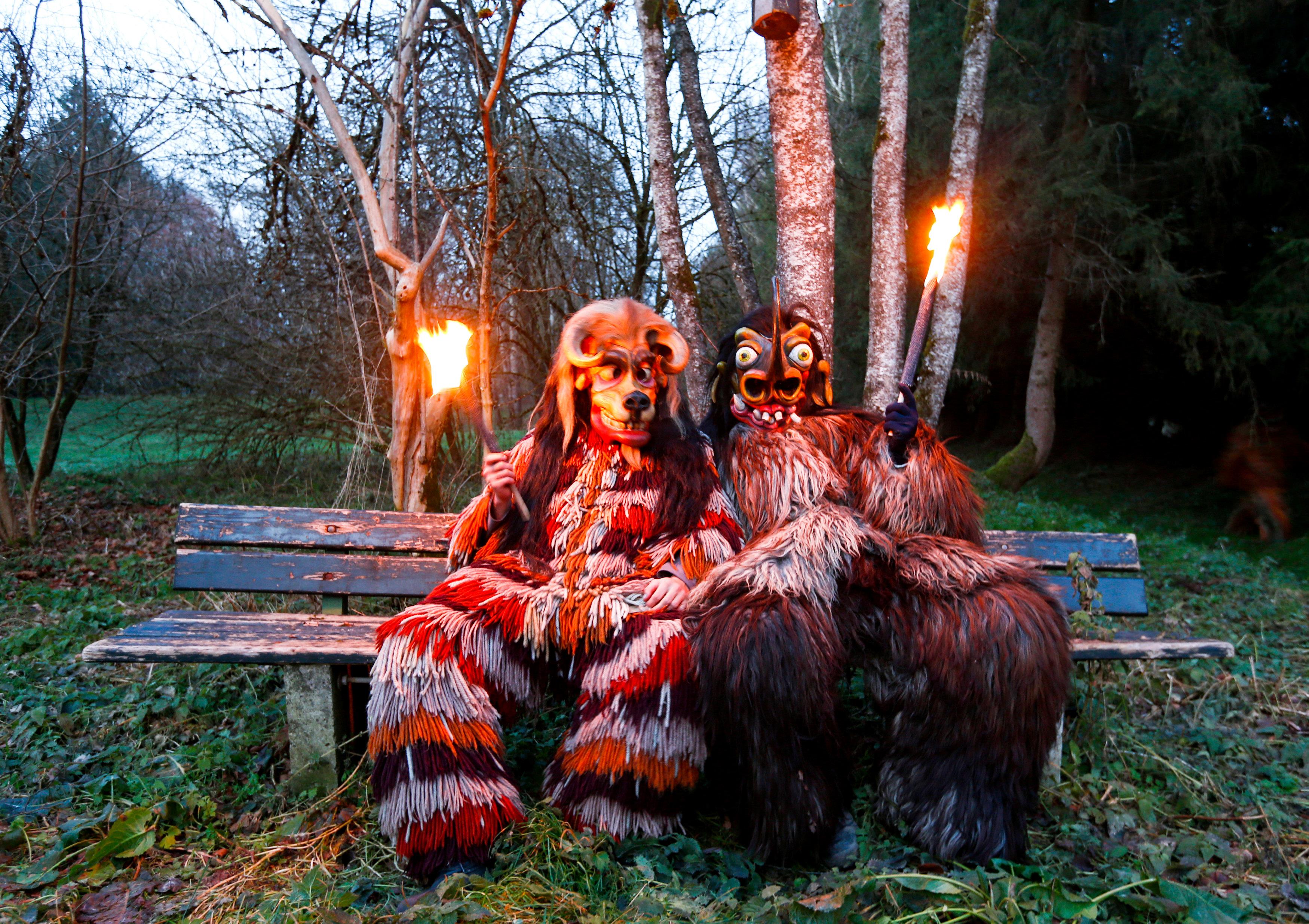 Costumed participants take break during Perchten parade in Osterseeon