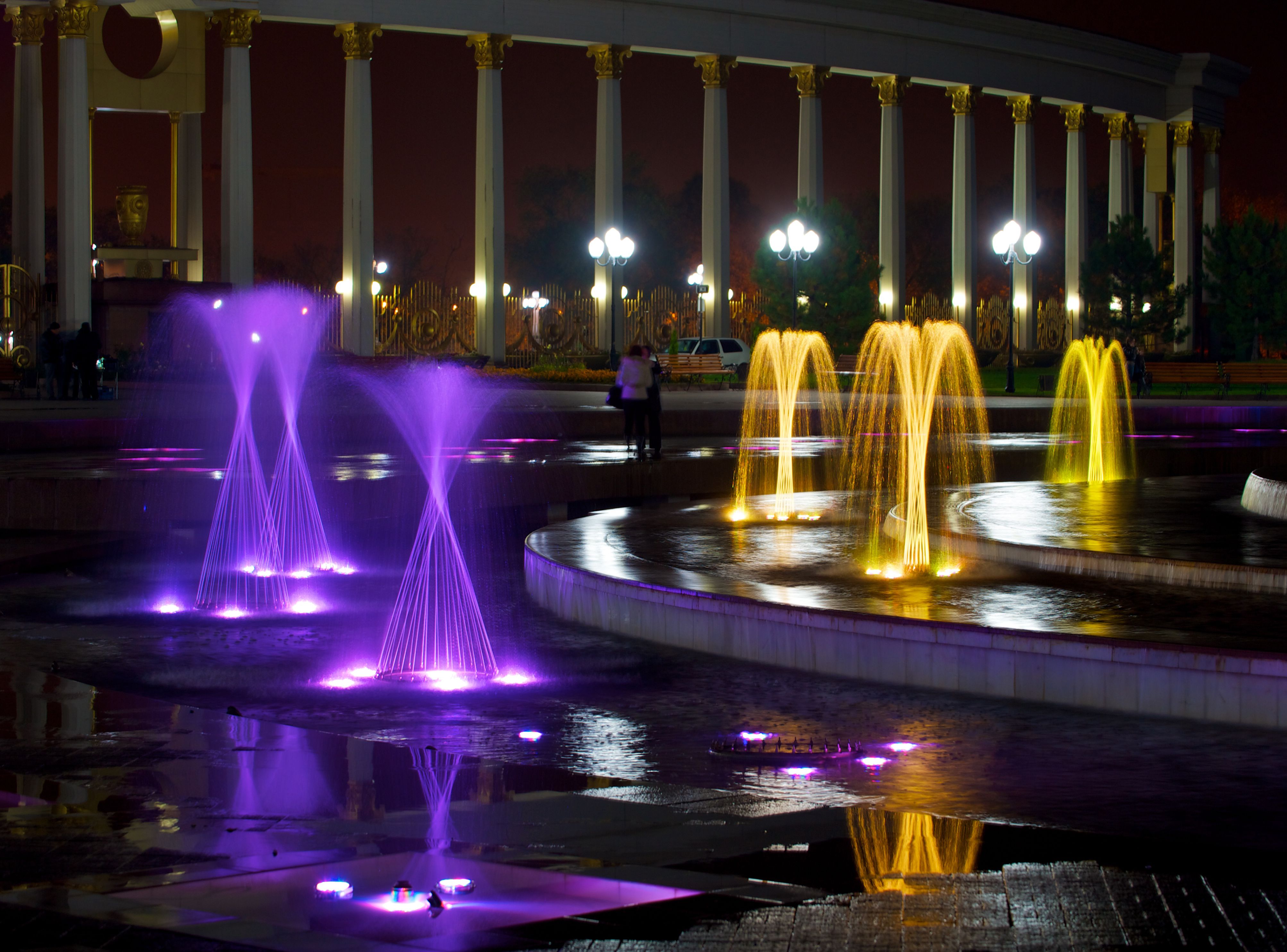Park w Ałma-Acie nocą. Kolorowo podświetlone fontanny