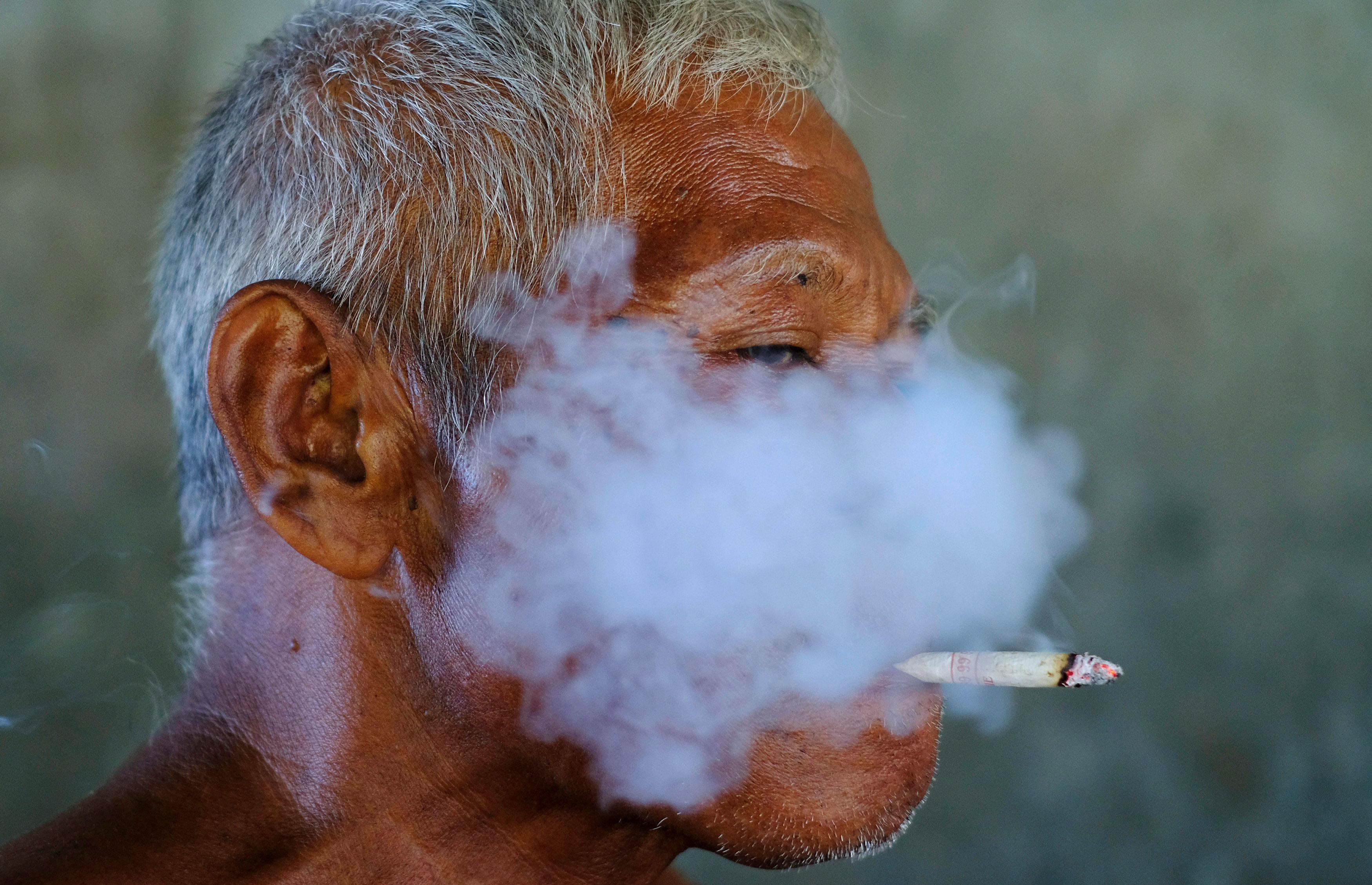 A worker smokes a cigarette during a break at a fabric factory in Solo
