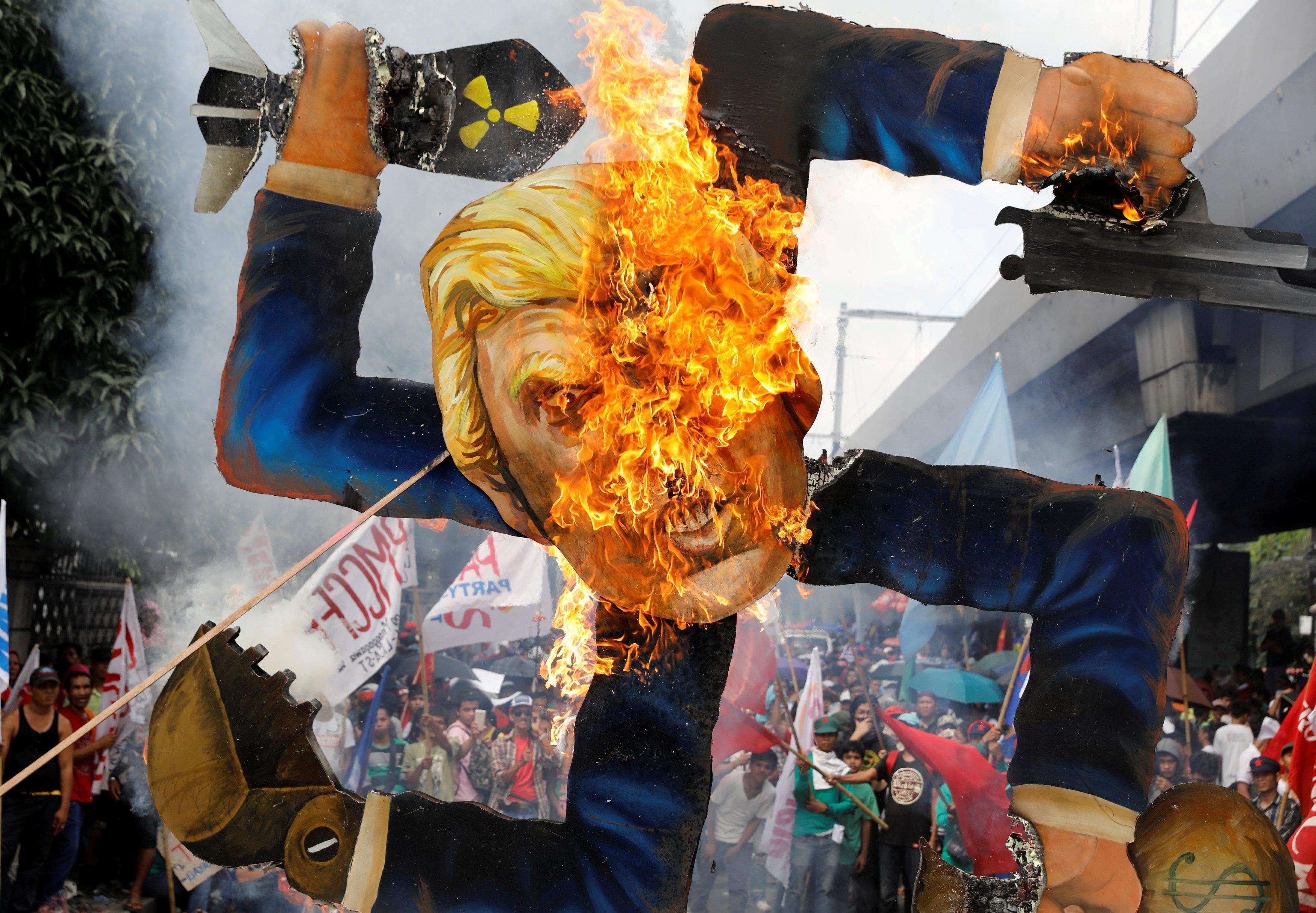 Protesters burn an effigy of U.S. President Trump, who is attending the ASEAN Summit and related mee
