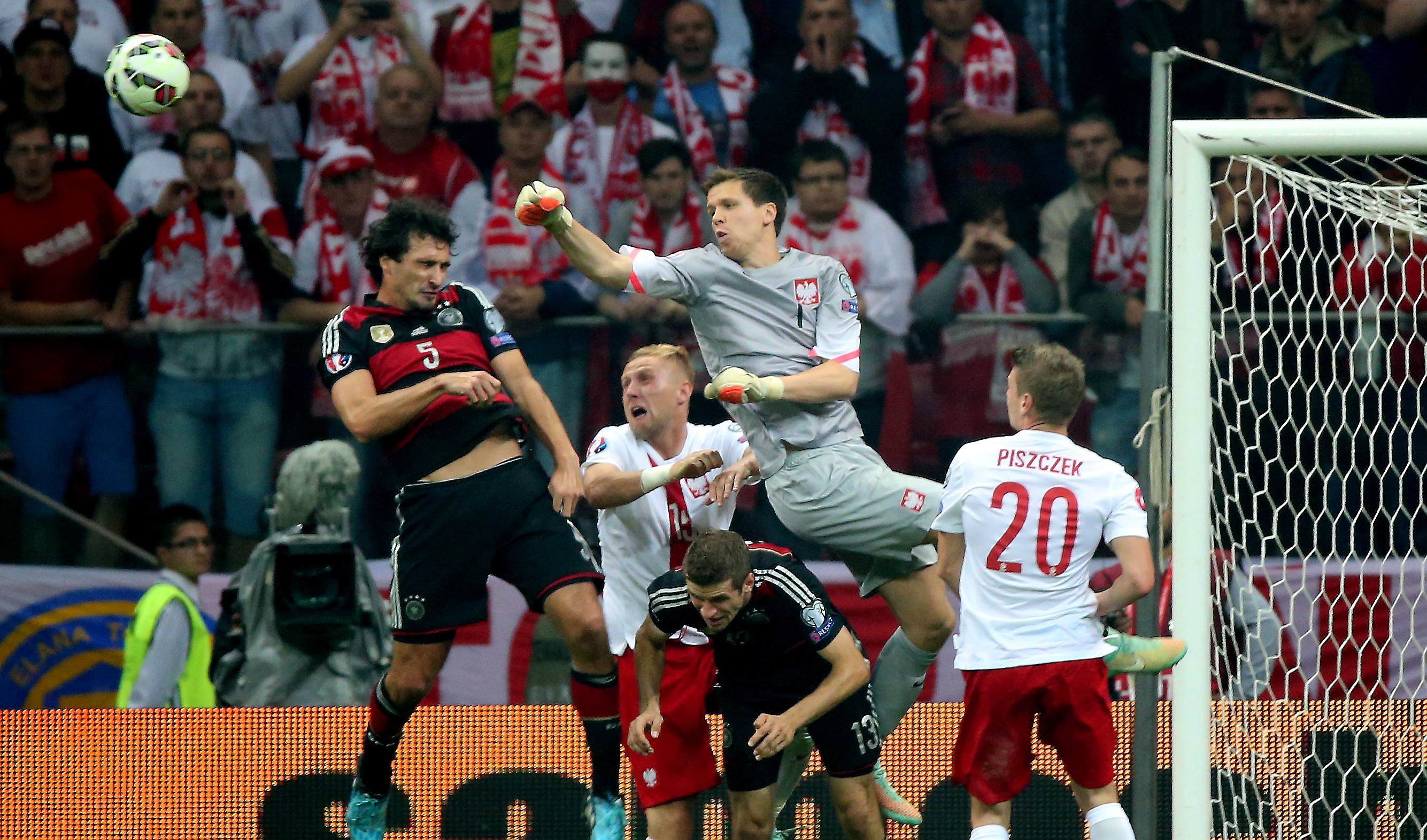 Wojciech Szczęsny (C) walczy o piłkę z Niemcem Matsem Hummelsem (L)