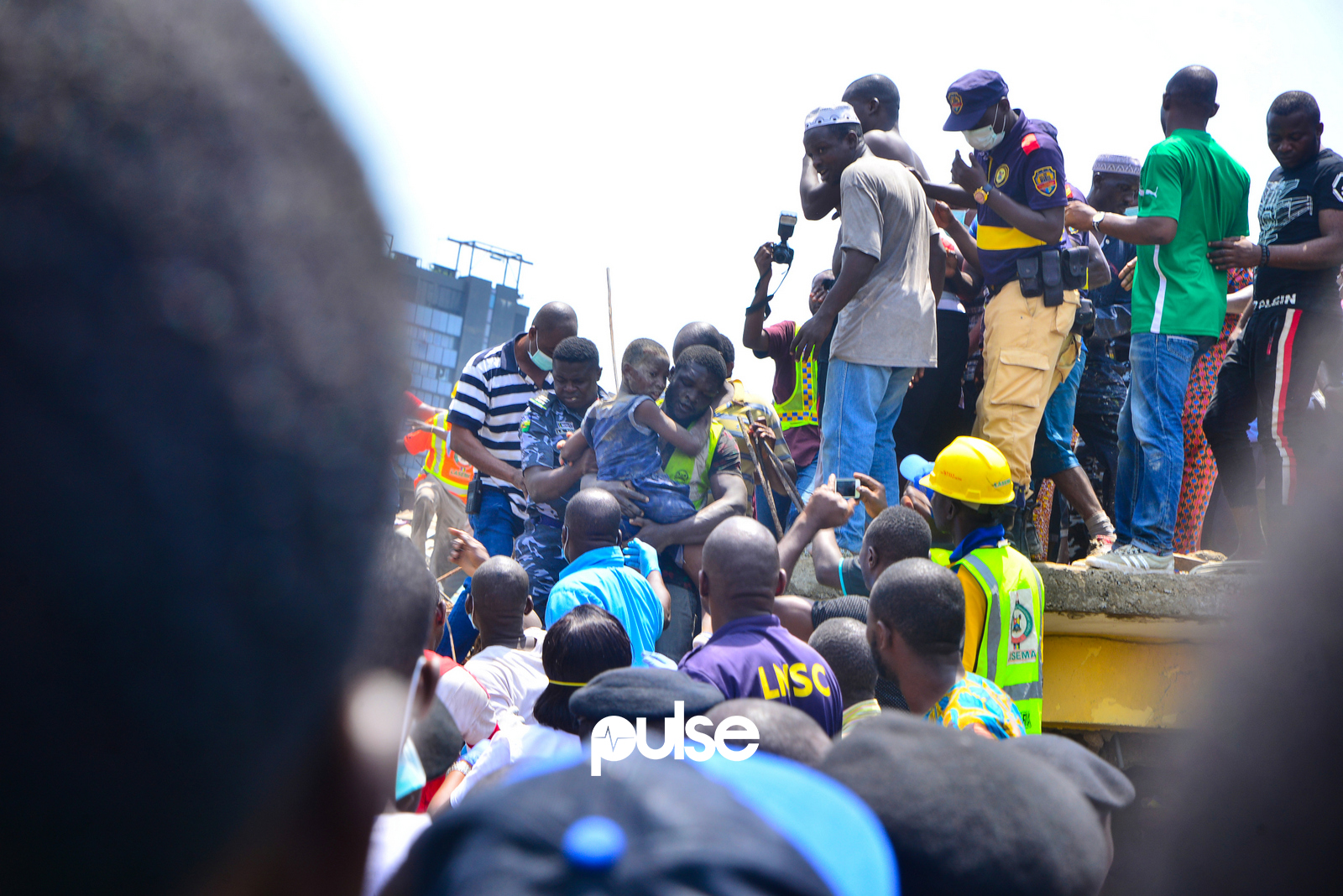 Rescuers on the debris of the collapsed building. (Pulse Nigeria)