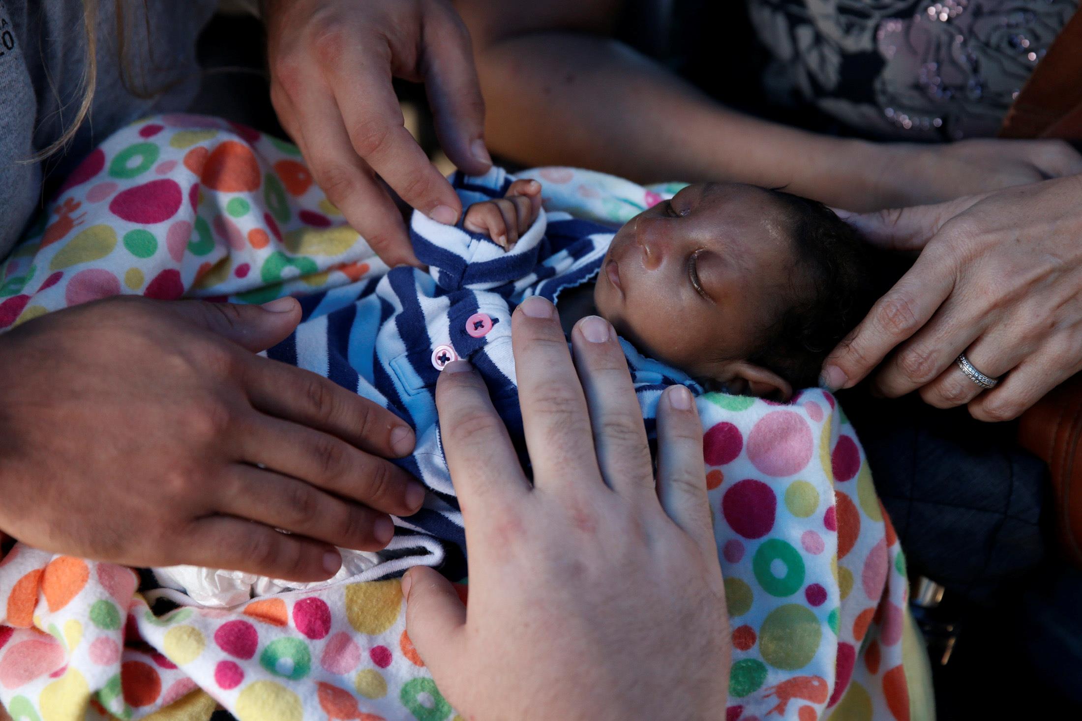 People pray over three-month-old Micah after Hurricane Matthew hit Jeremie