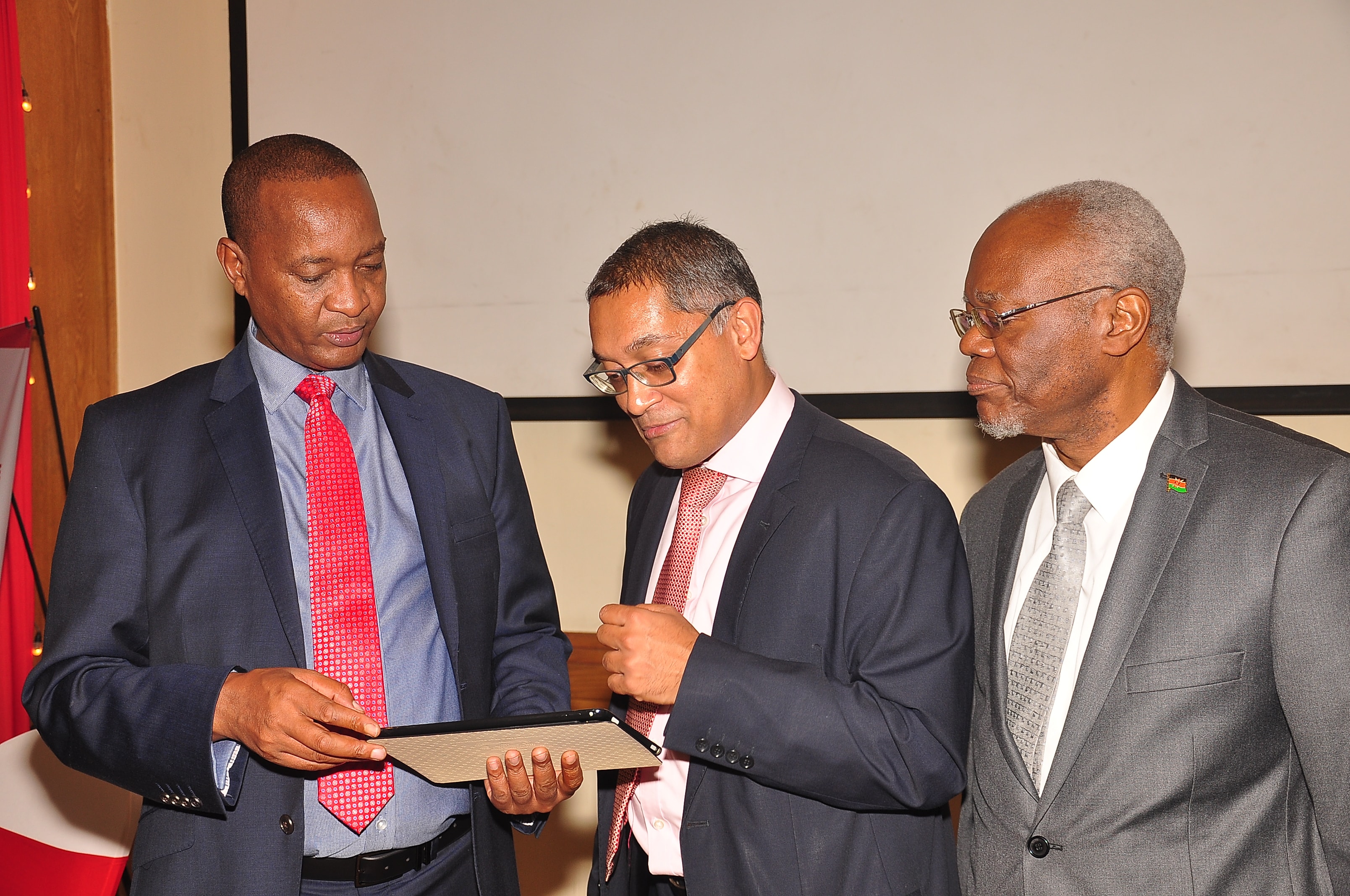 Kenya Re Managing Director Mr. Jadiah Mwarania (L), Dry Associates Investment Bank GM, Mr. Ewart Salins (C)  and Kenya Re Chairman Mr. Chiboli Shakaba (R) discuss some figures during the Kenya Re Half Year Investor briefing held at the Intercontinental Hotel on the 2nd of August 2019.