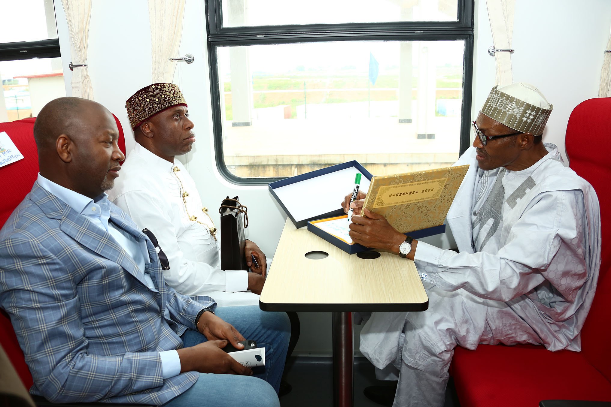 President Muhammadu Buhari takes a train ride with the Minister of Transport, Rotimi Amaechi and the Minister of state for Aviation, Hadi Sarika. [DailyPost]