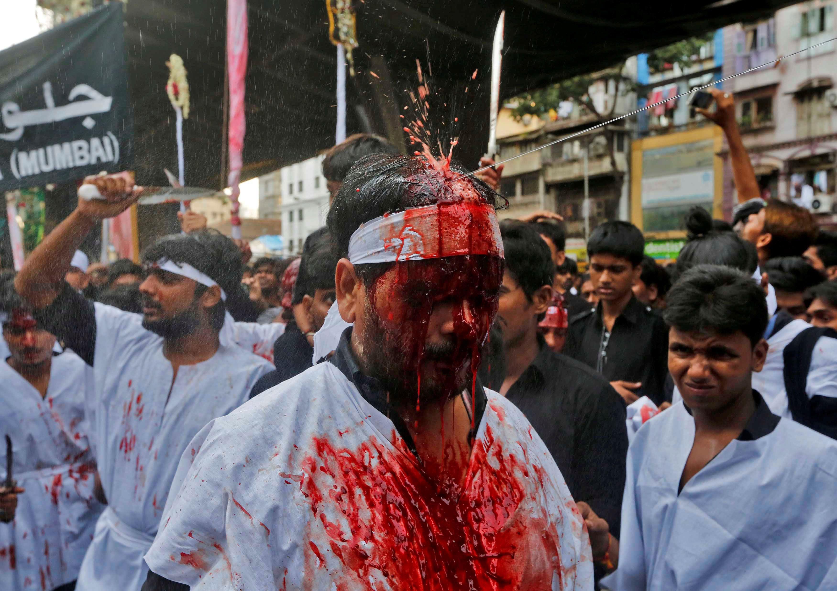 A Shi'ite muslim mourner is sprayed with rose water after he flagellated himself during a Muharram p