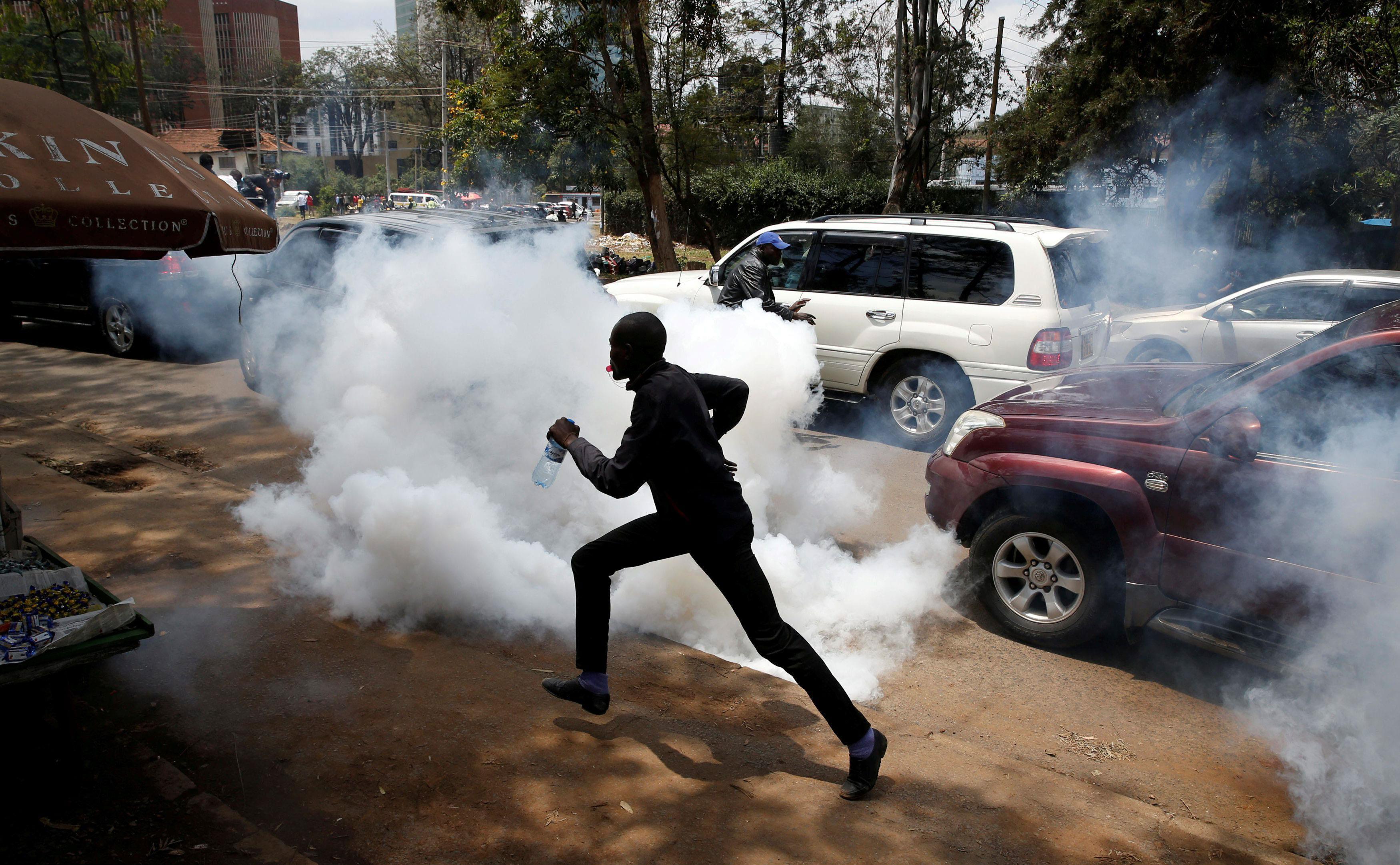 Supporters of Kenyan opposition National Super Alliance coalition run after policemen fired tear gas