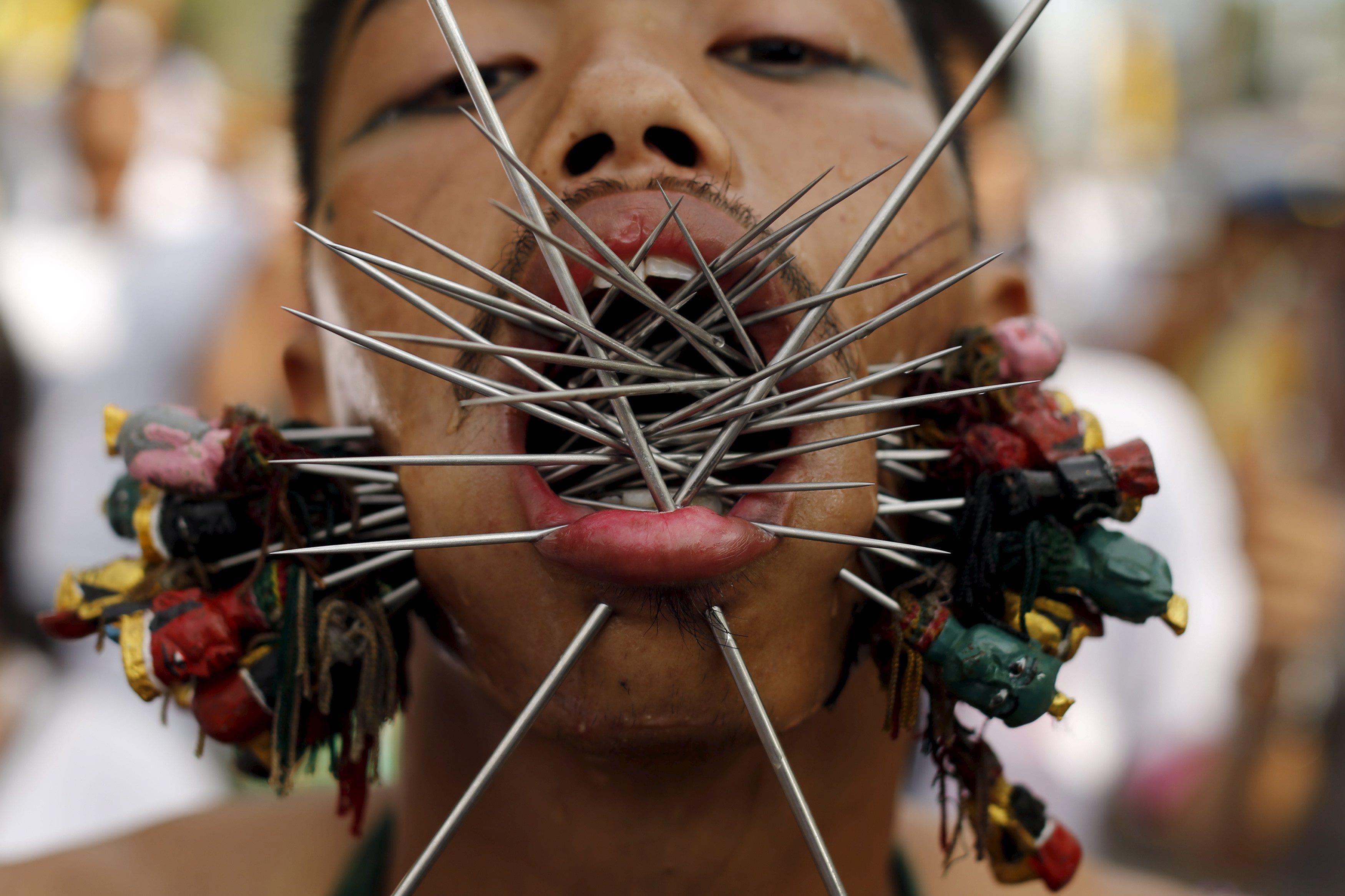 A devotee of the Chinese Samkong Shrine walks with spikes pierced through his cheeks during a proces
