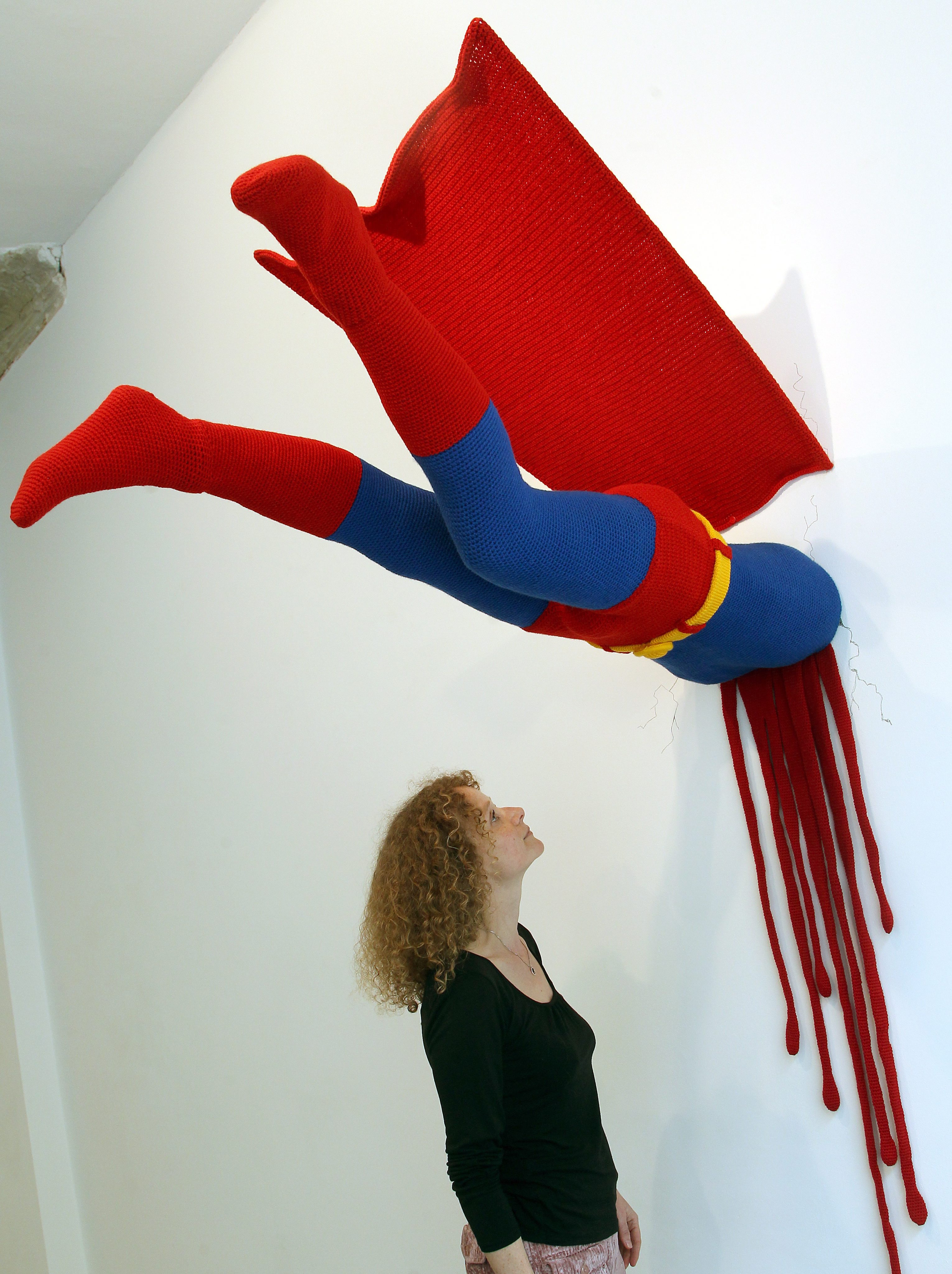 Ociekający krwią Superman, któremu nie udało się przebić przez ścianę.