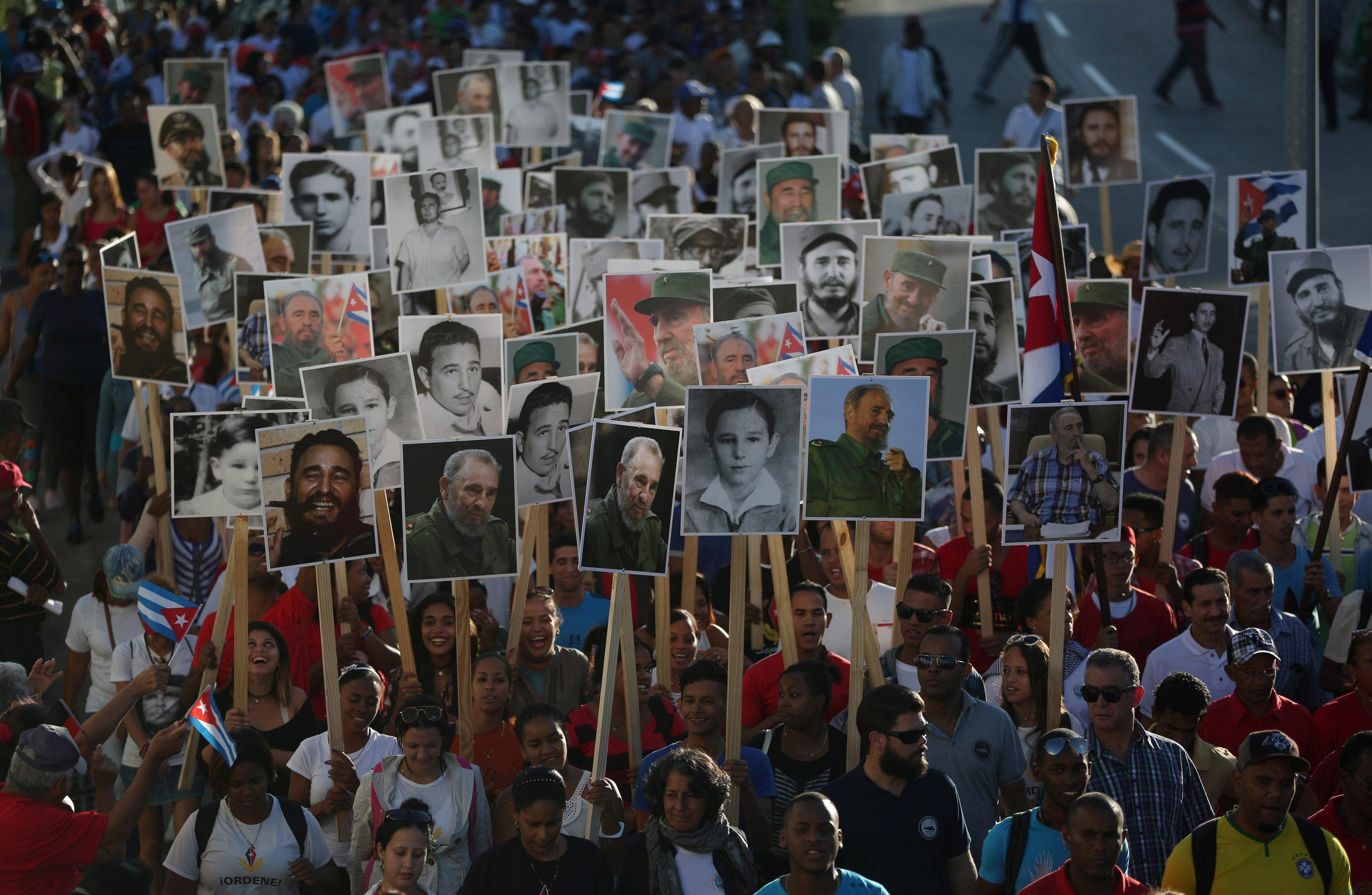 People carry images of late Cuban President Fidel Castro during a march to Santa Ifigenia Cemetery t