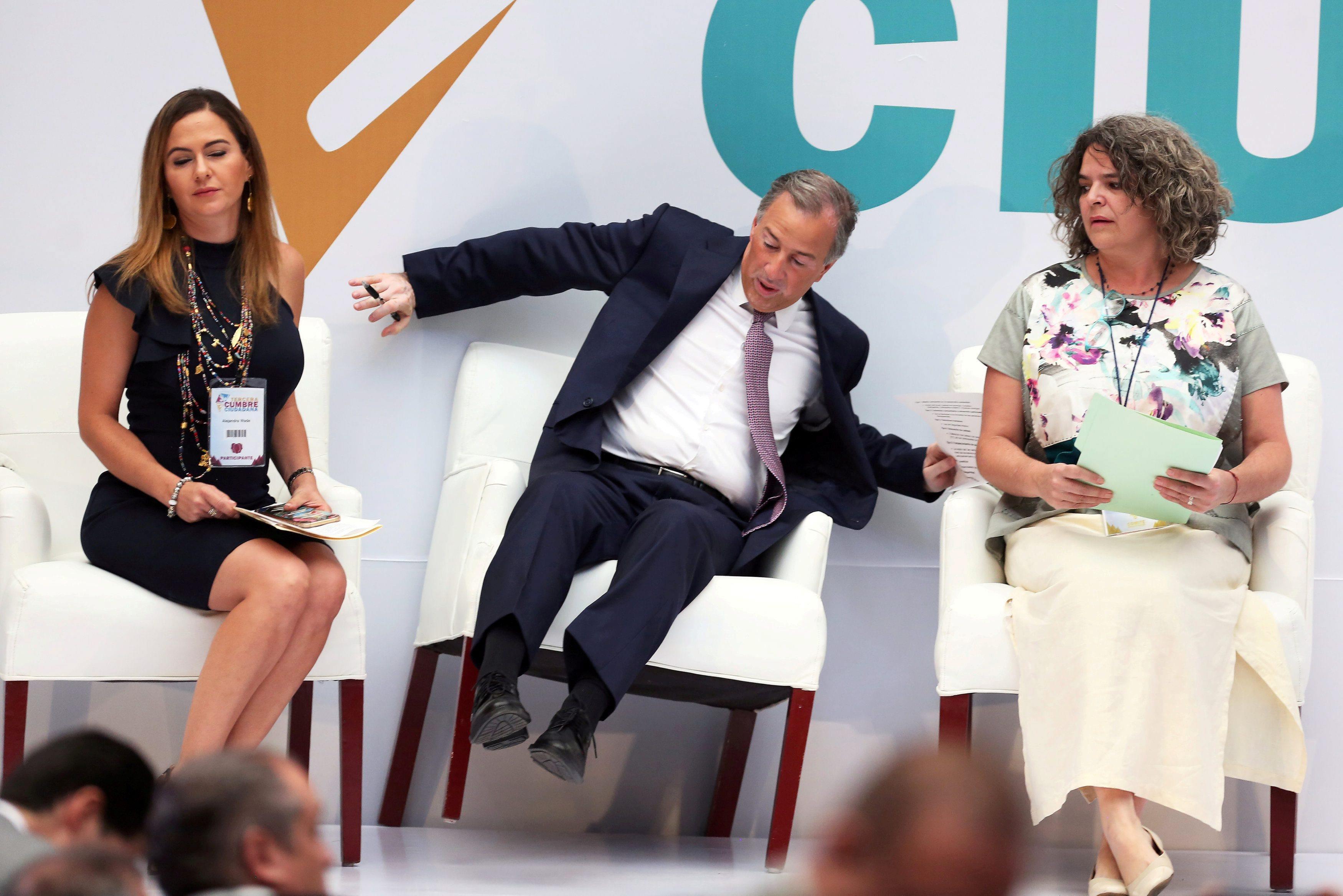 PRI presidential candidate Jose Antonio Meade reacts while falling off his chair after arriving to a