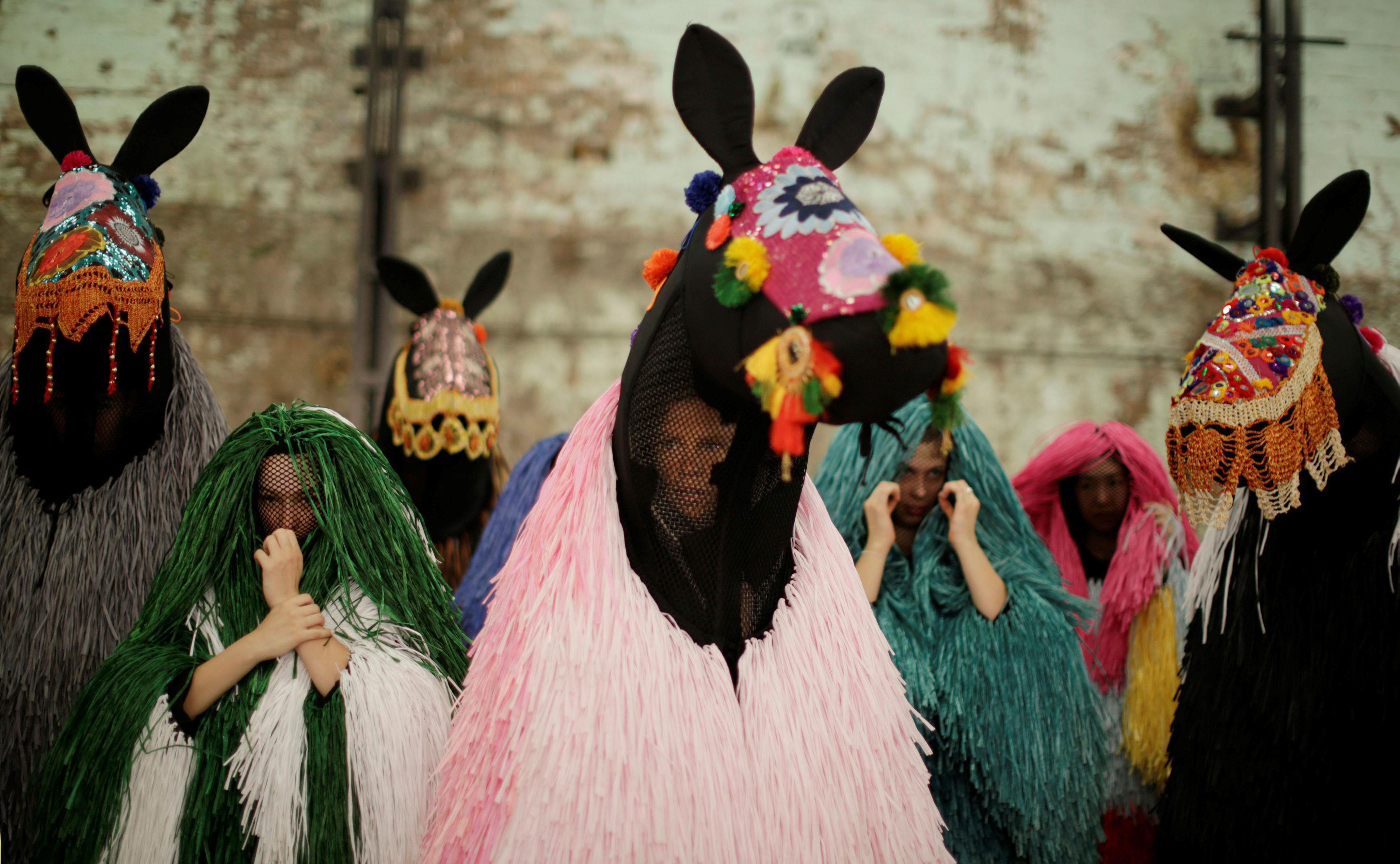 Dancers dressed as a horses listen to instruction from a choreographer during a press preview by Ame
