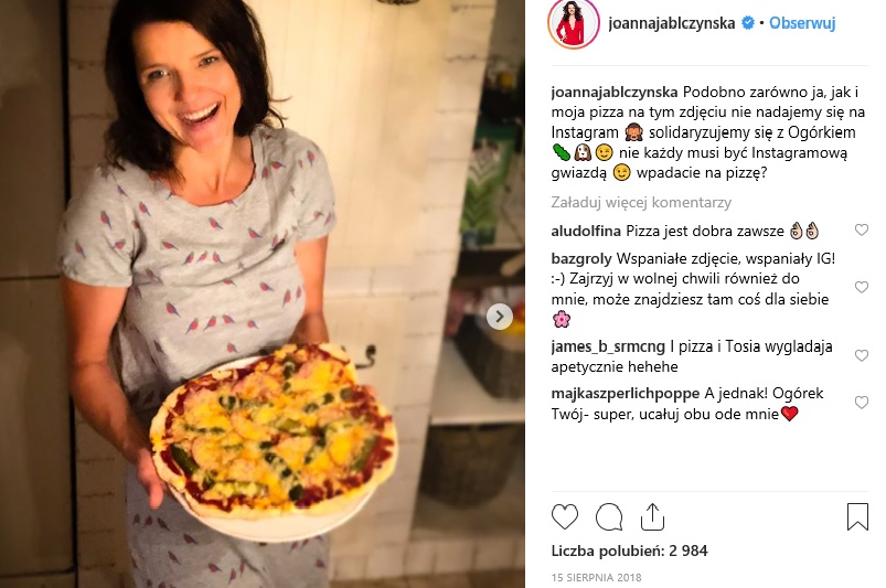 W kuchni Joanna Jabłczyńska także postawiła na sprawdzone rozwiązania – pastelowe kolory i biel. Uwagę przyciągają: duży drewniany stół i ścianka wyłożona kafelkami, na której znalazło się miejsce na przechowywanie zapasów i przypraw.