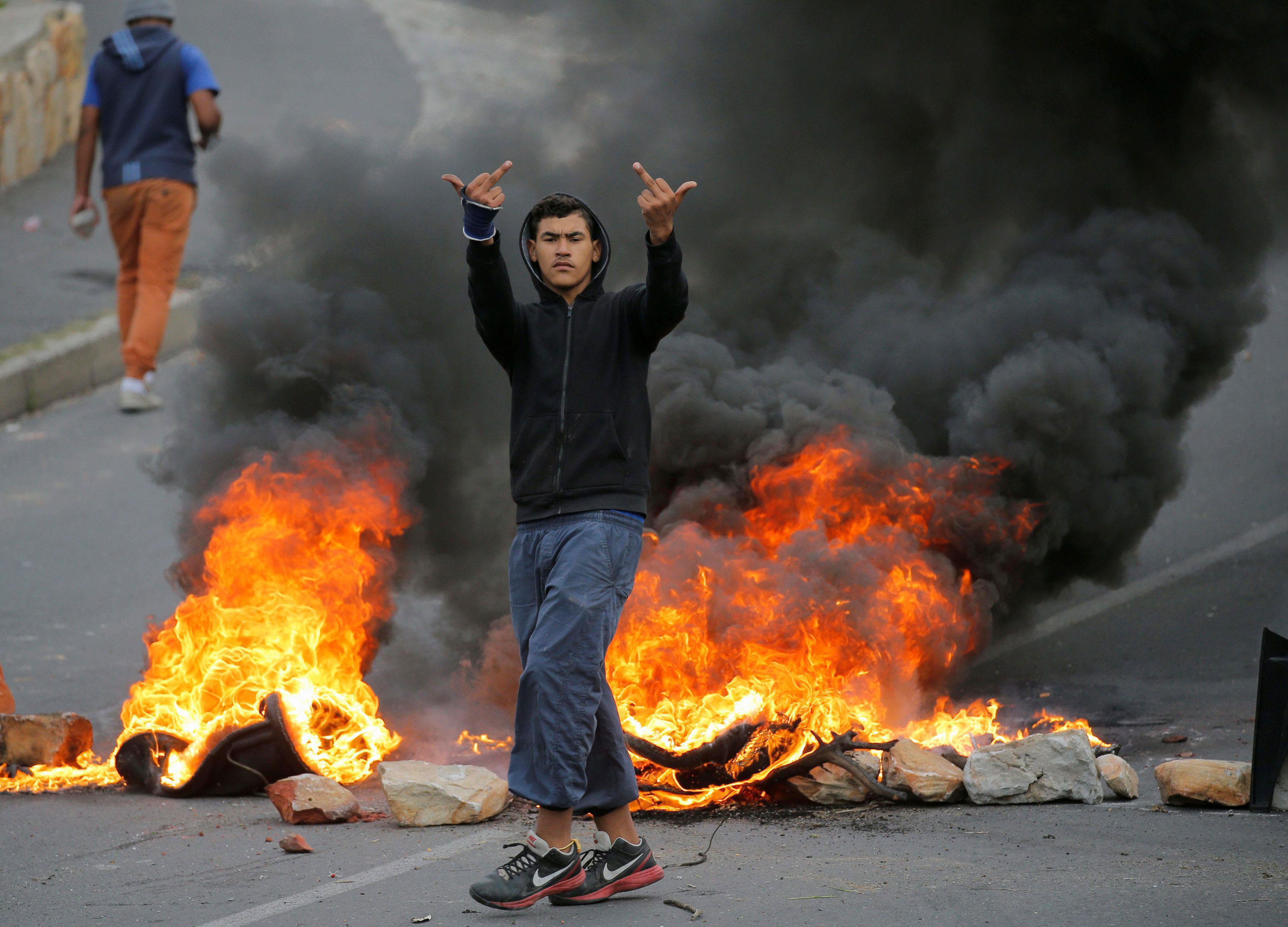 Protesters stand before barricades in Hout Bay, Cape Town