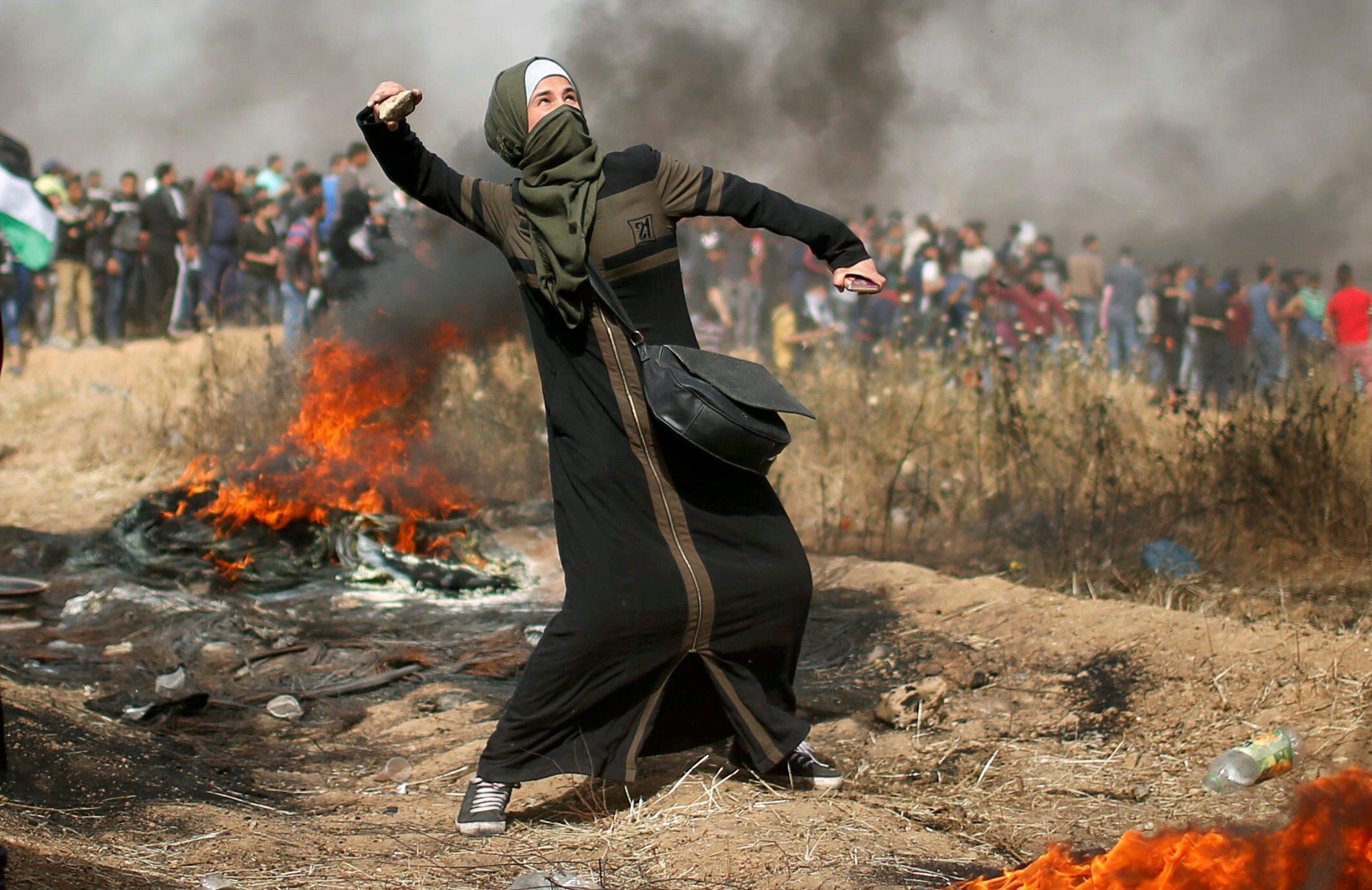 Girl hurls stones during clashes with Israeli troops at a protest where Palestinians demand the righ