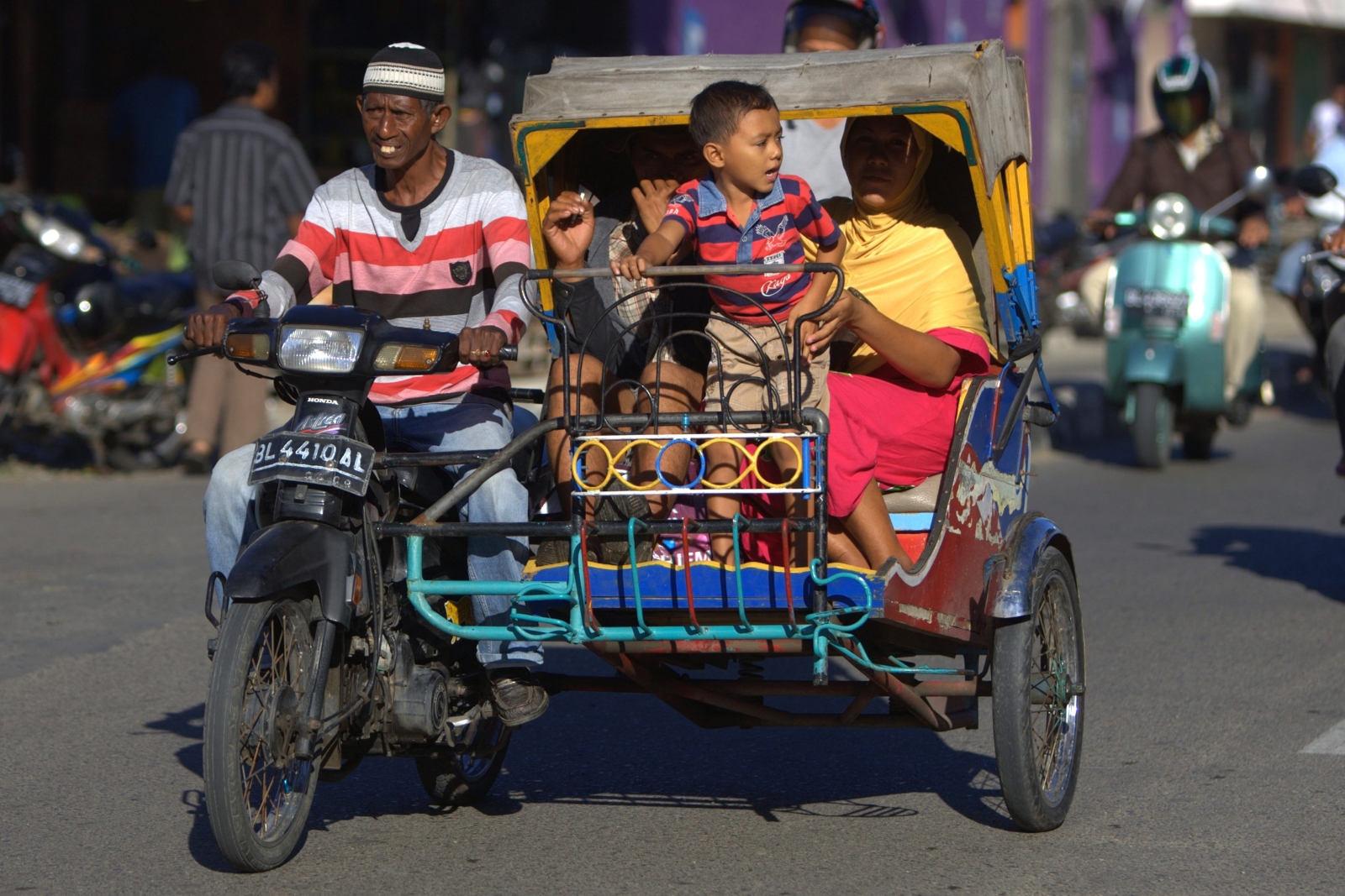 Rikszarz jedzie z rodziną ulicami Banda Aceh w Indonezji