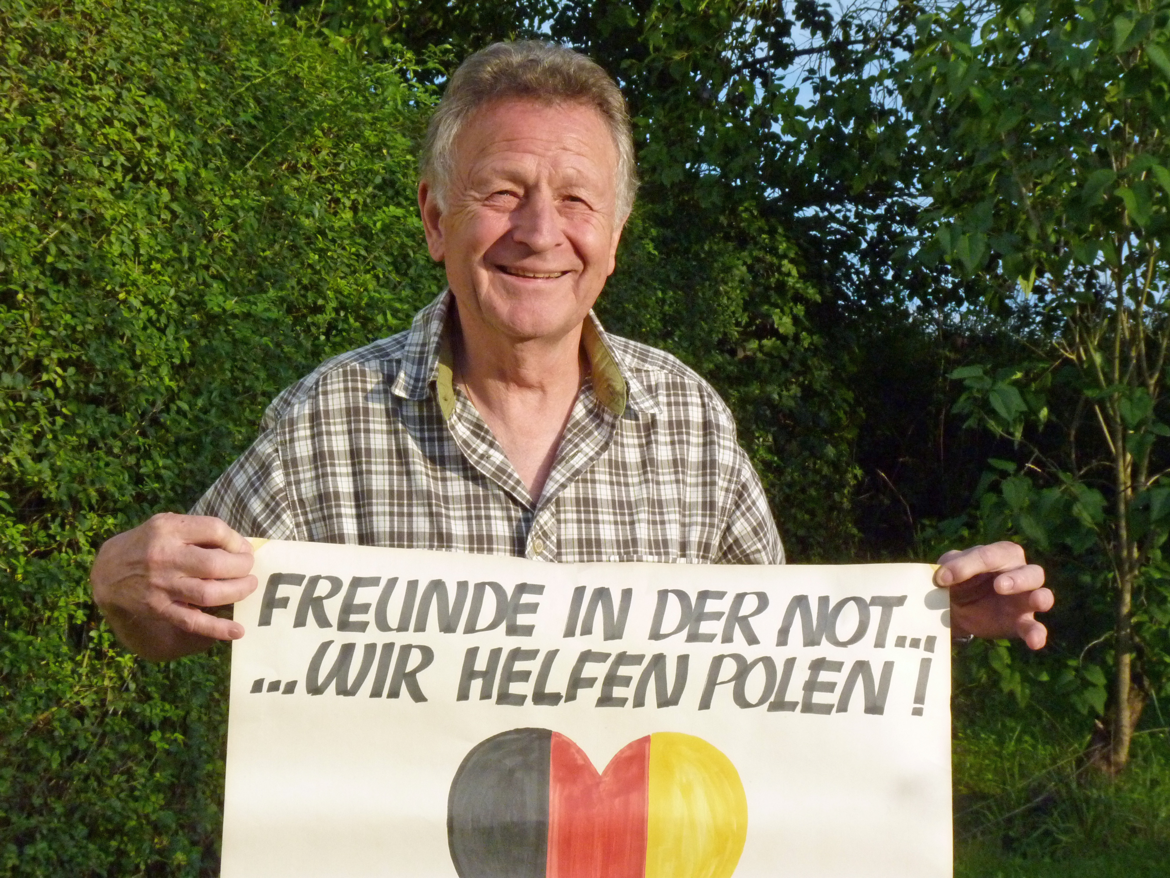 Walter MATT z plakatem do swojej akcji Pomagamy przyjaciolom w Polsce