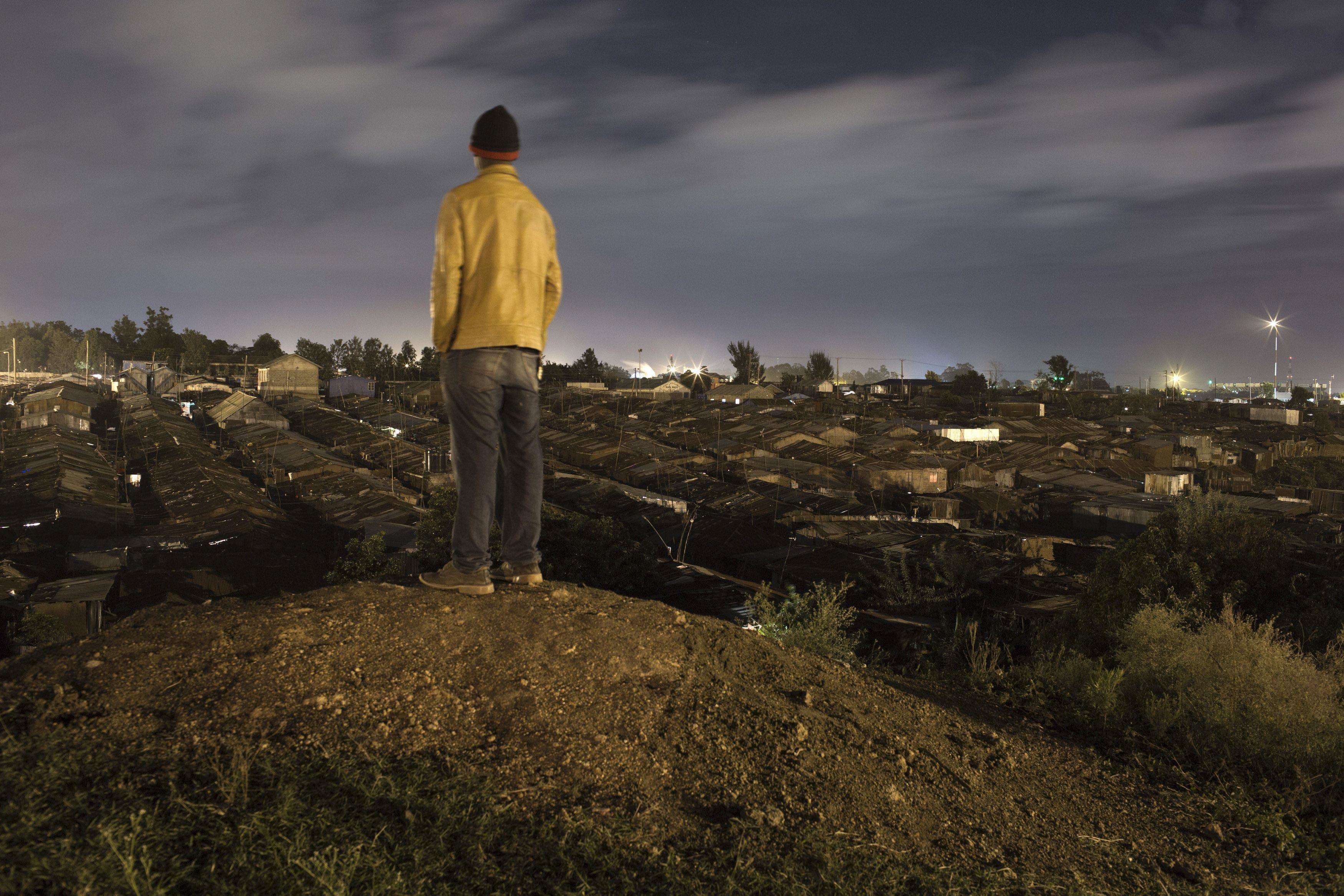 A man stands on a hilltop overlooking Korogocho in Nairobi