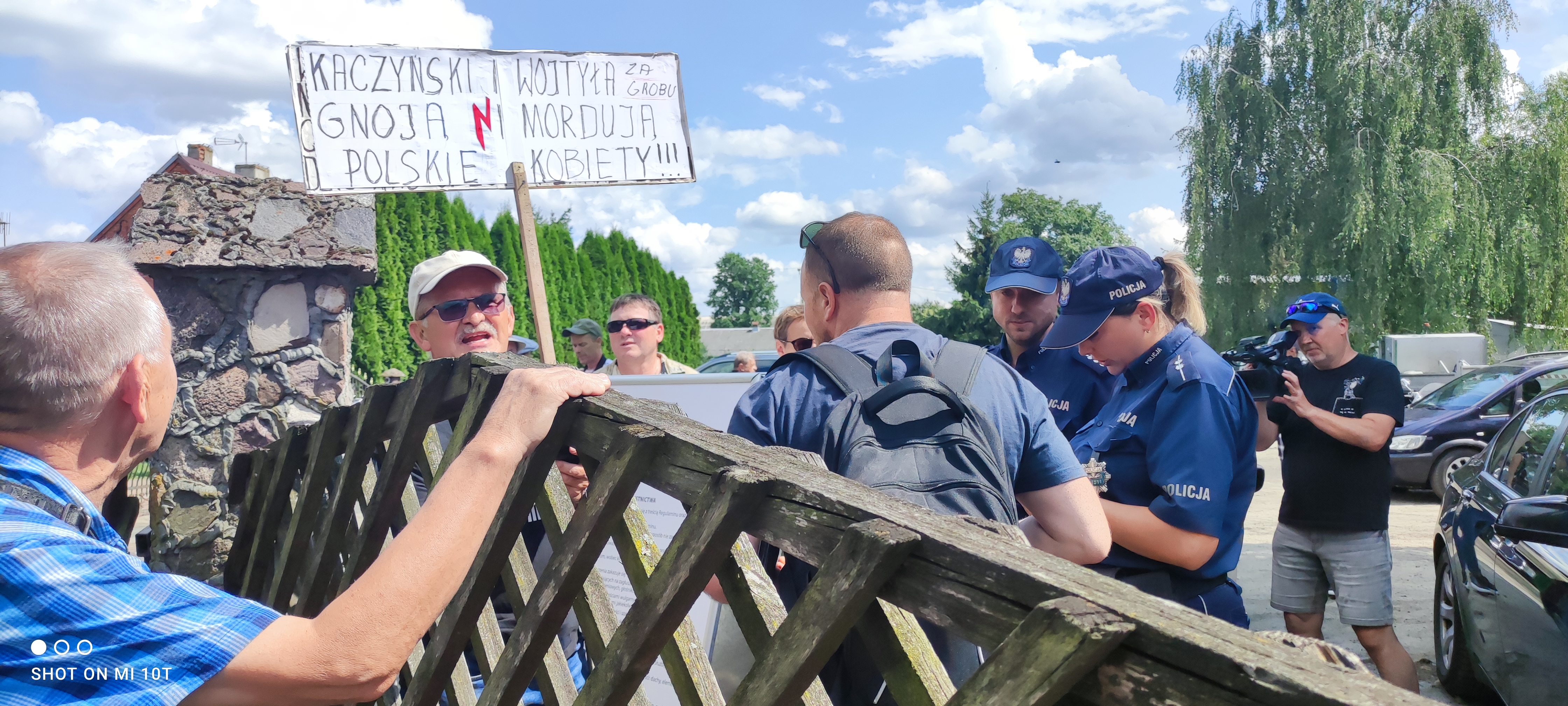 Mężczyzna z transparentem zostaje wyprowadzony przez policję za bramę stadionu. I tam – do końca festynu – pilnowany przez funkcjonariuszy.