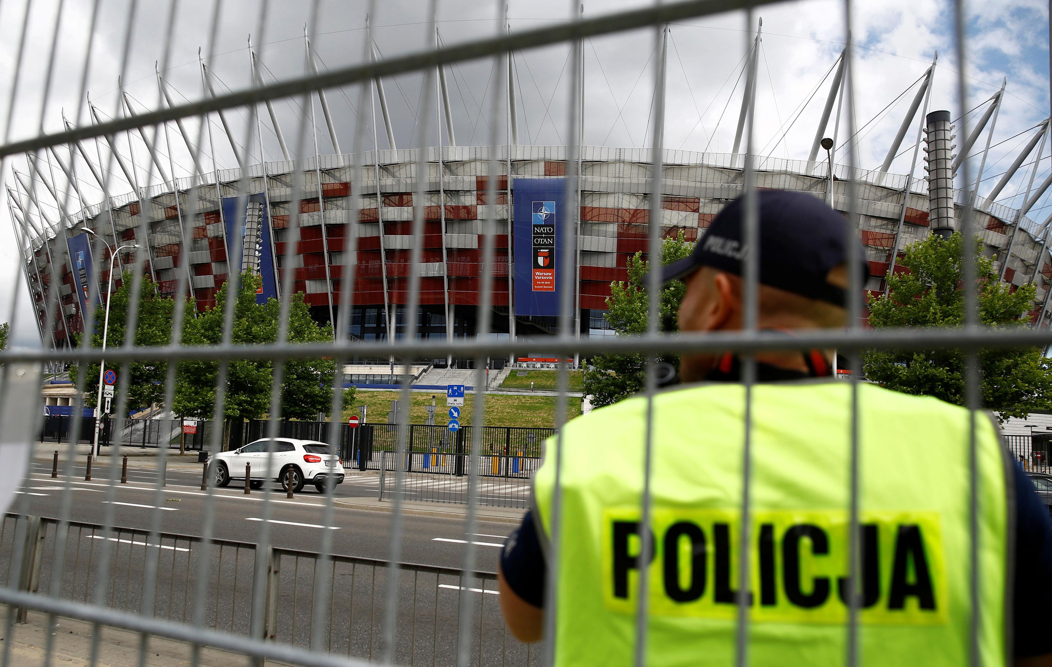 Polish police officer stands guard in front of the PGE National Stadium, the venue of the NATO Summi