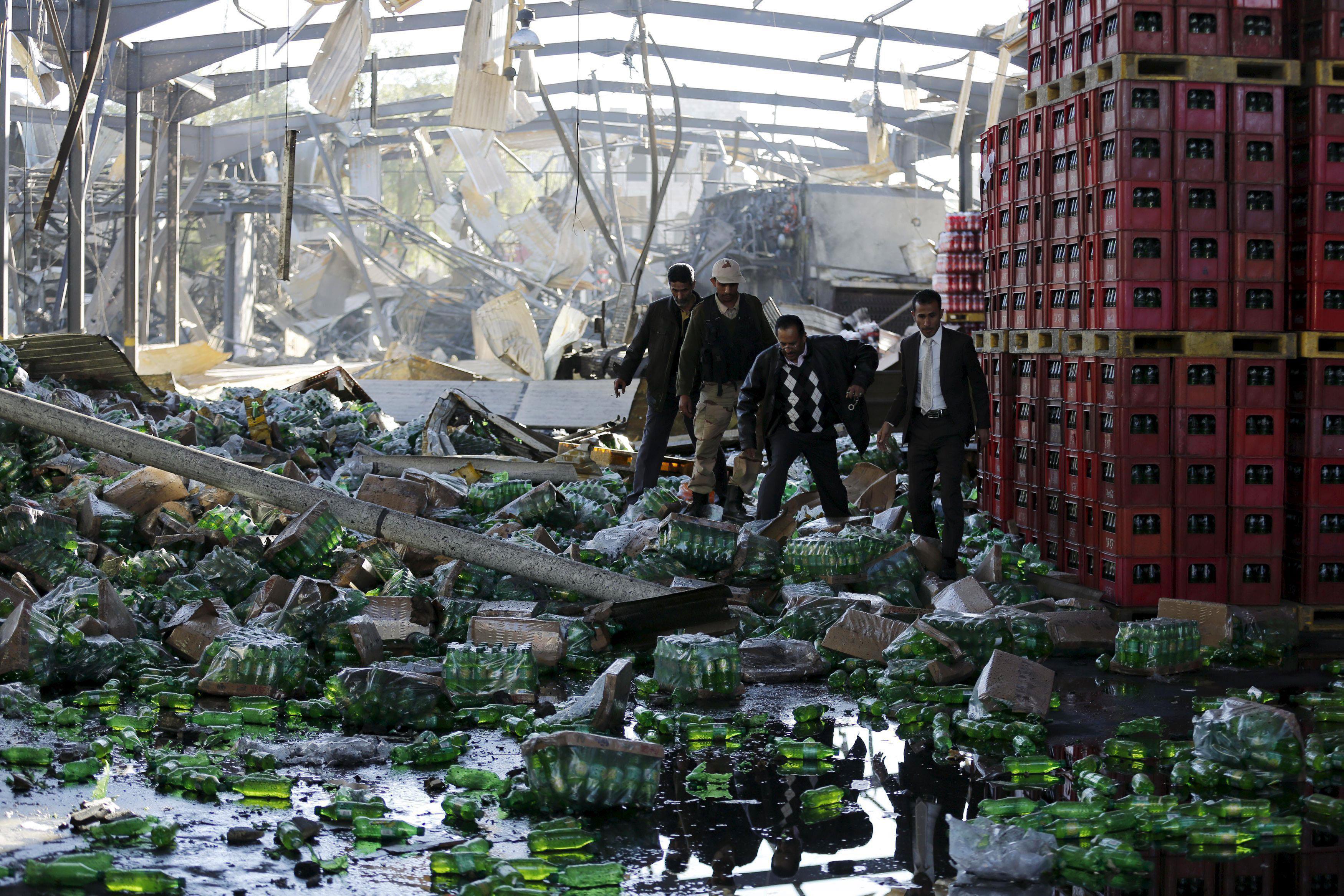 Officials inspect damage at a Coca-Cola beverages factory after Saudi-led air strikes destroyed it i