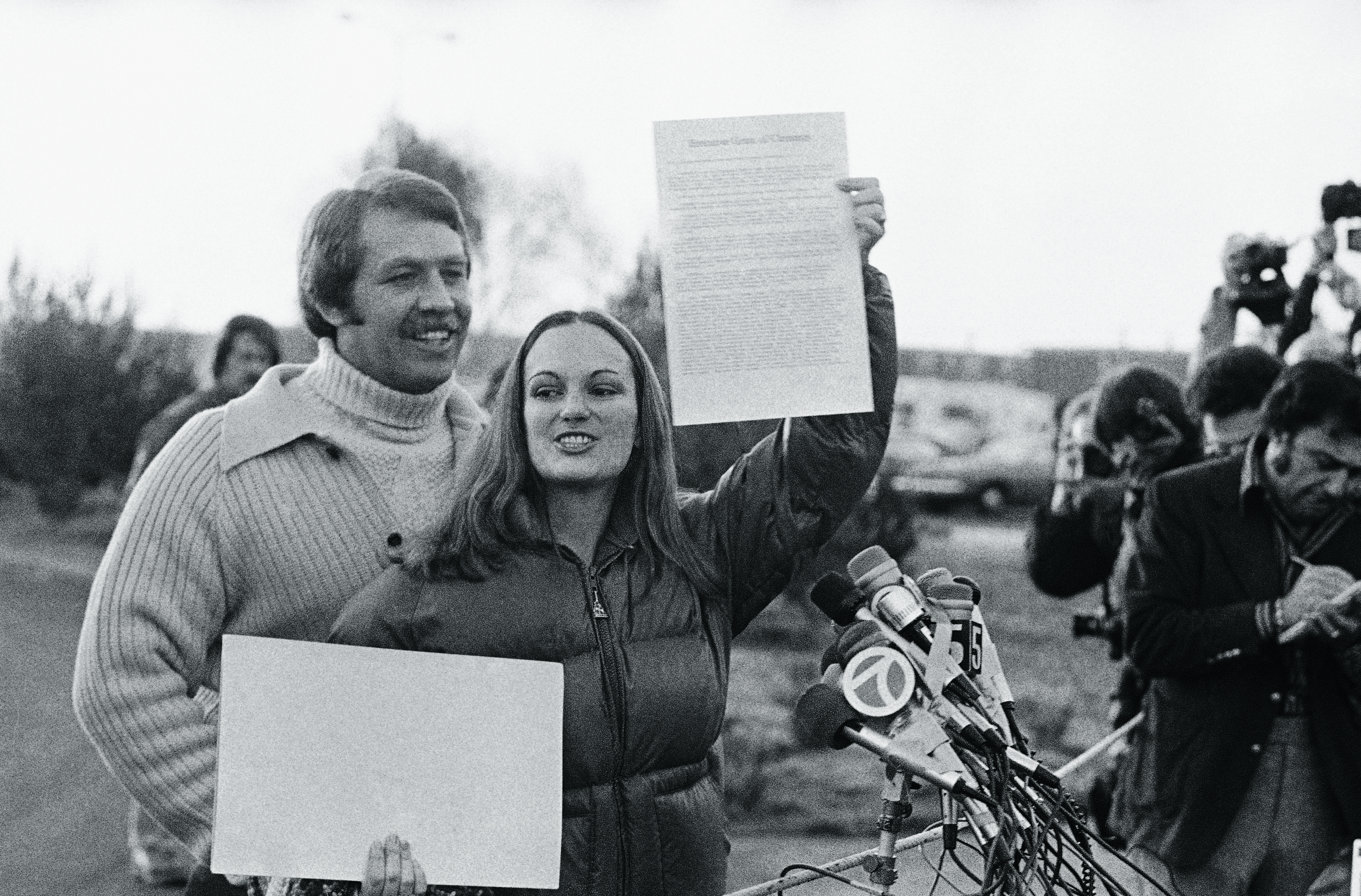 Patricia Hearst i jej narzeczony Bernard Shaw pokazują prezydenckie złagodzenie wyroku po opuszczeniu przez Hearst Federalnego Zakładu Karnego w Pleasanton, 1 lutego 1979 r.