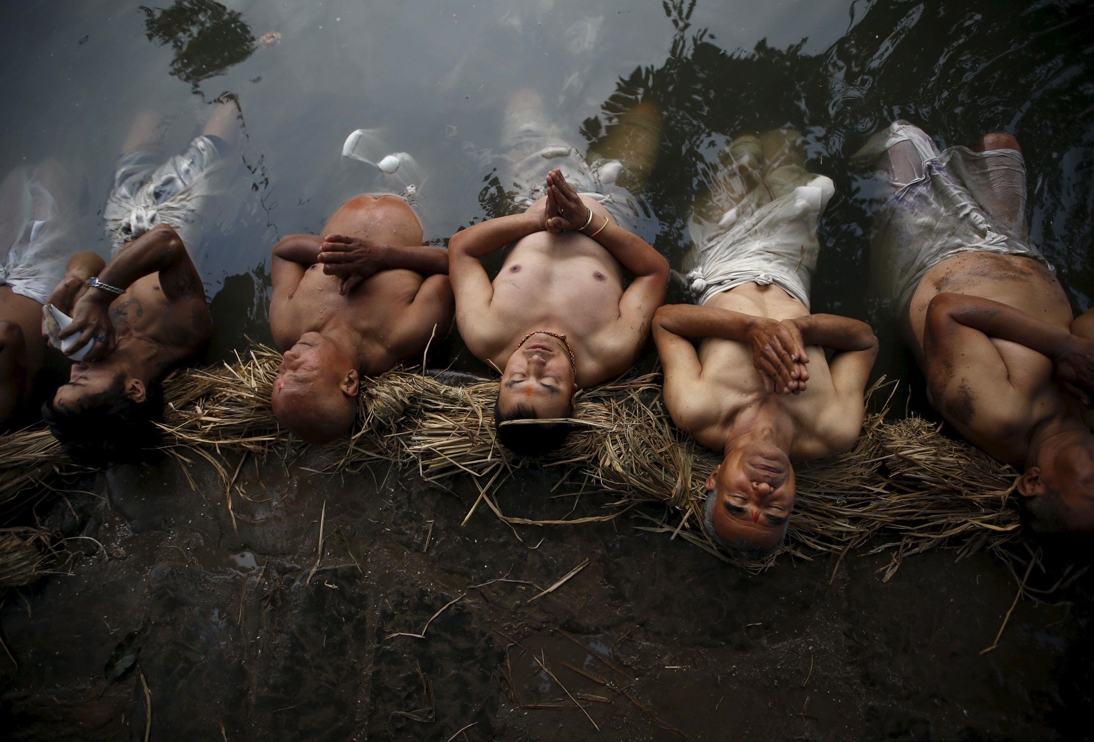 Devotees offer prayers by submerging themselves in the Hanumante River during a month-long Swasthani