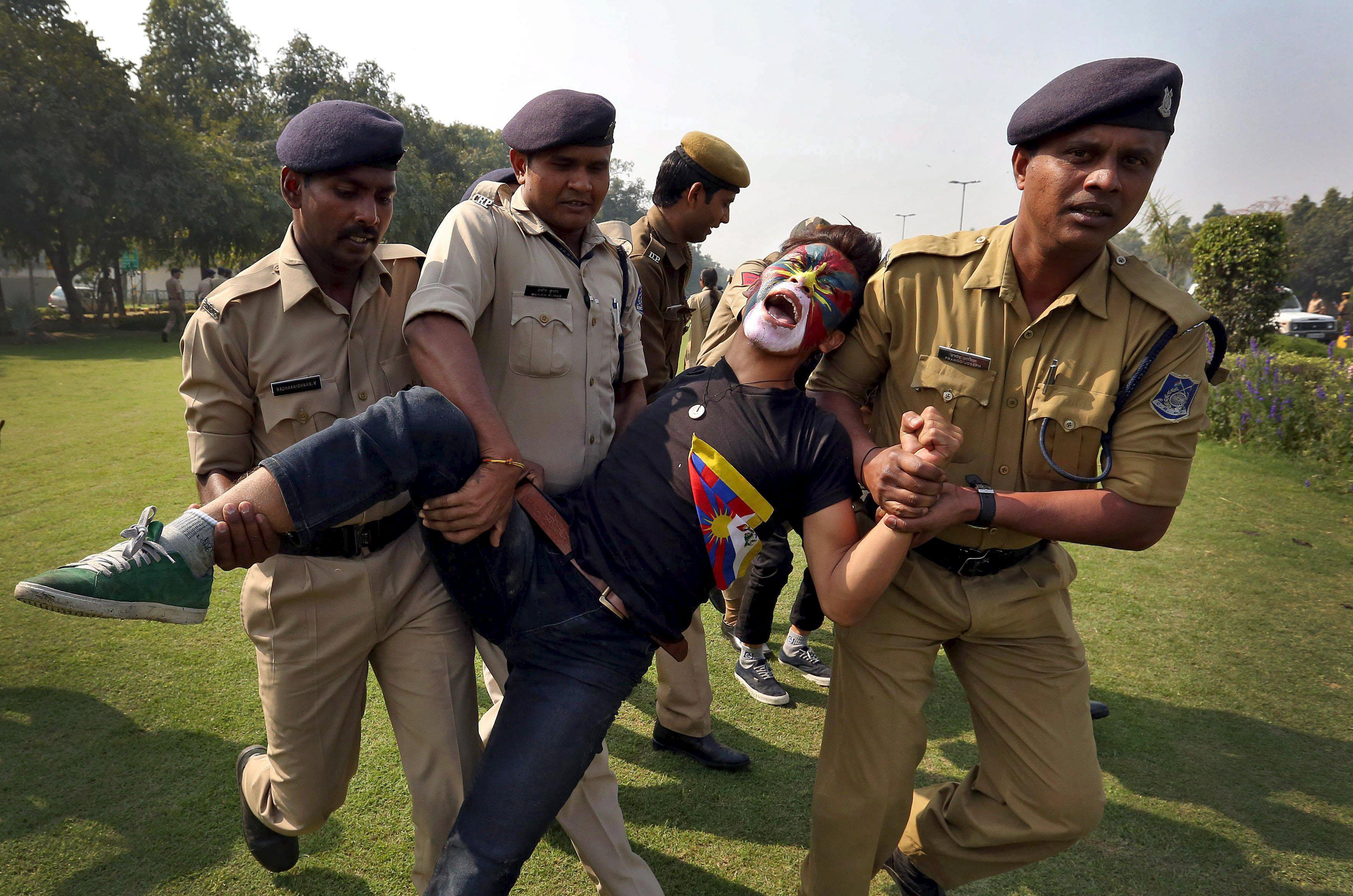 Indian police detain a Tibetan activist during a protest held to mark the 57th anniversary of the Ti