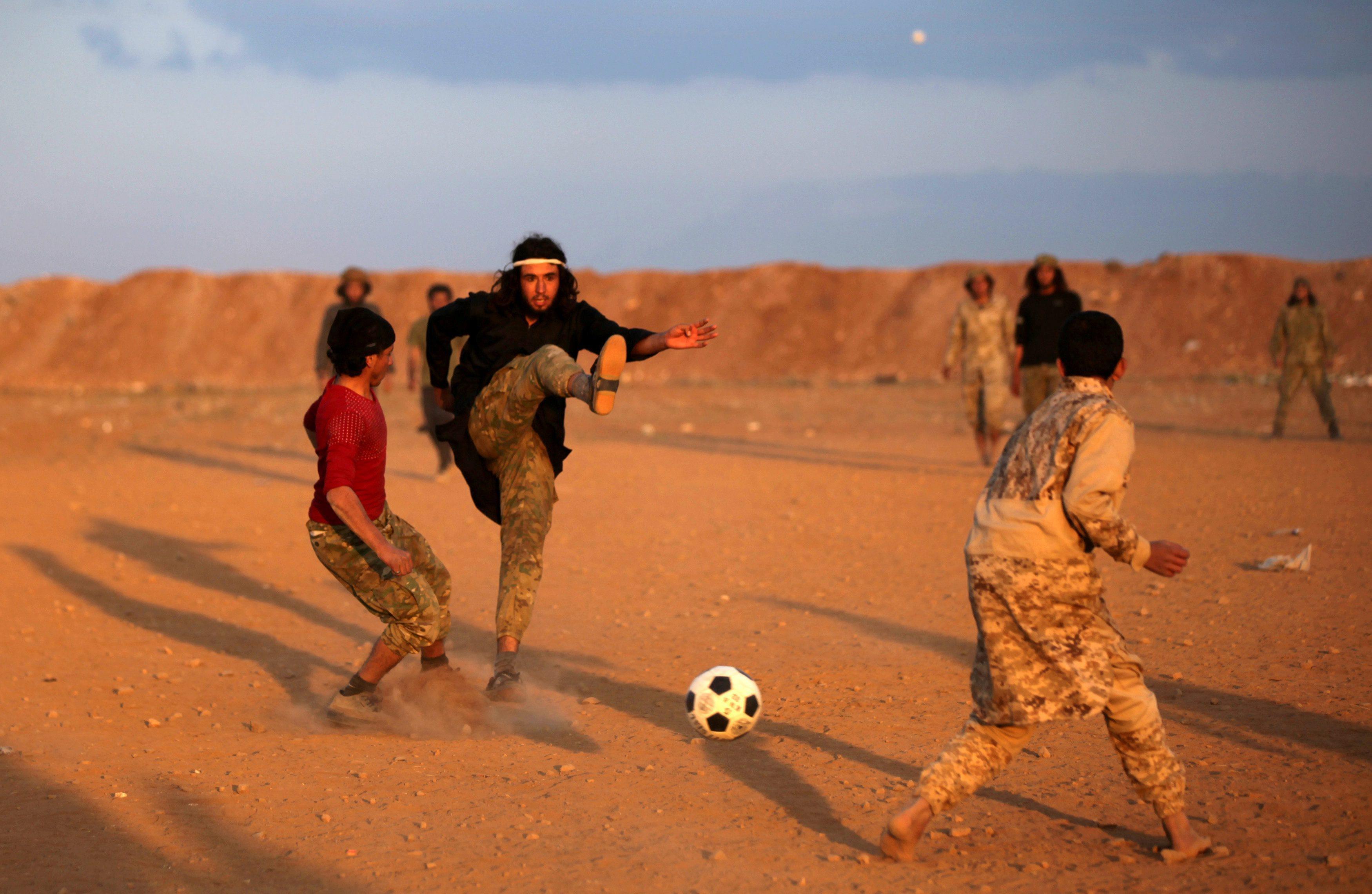 Free Syrian Army fighters play soccer in the northern Syrian town of al-Rai