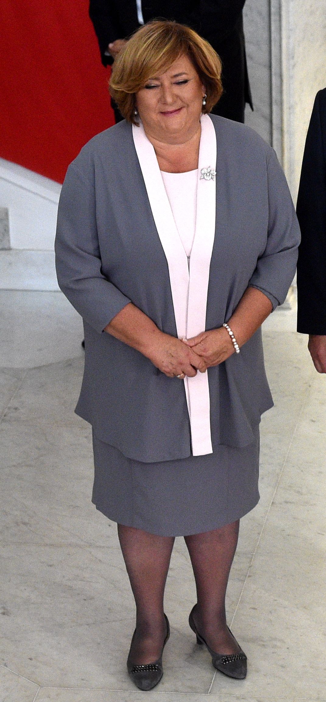 Była pierwsza dama wybrała na tę okazję szary kostium z białym akcentem.