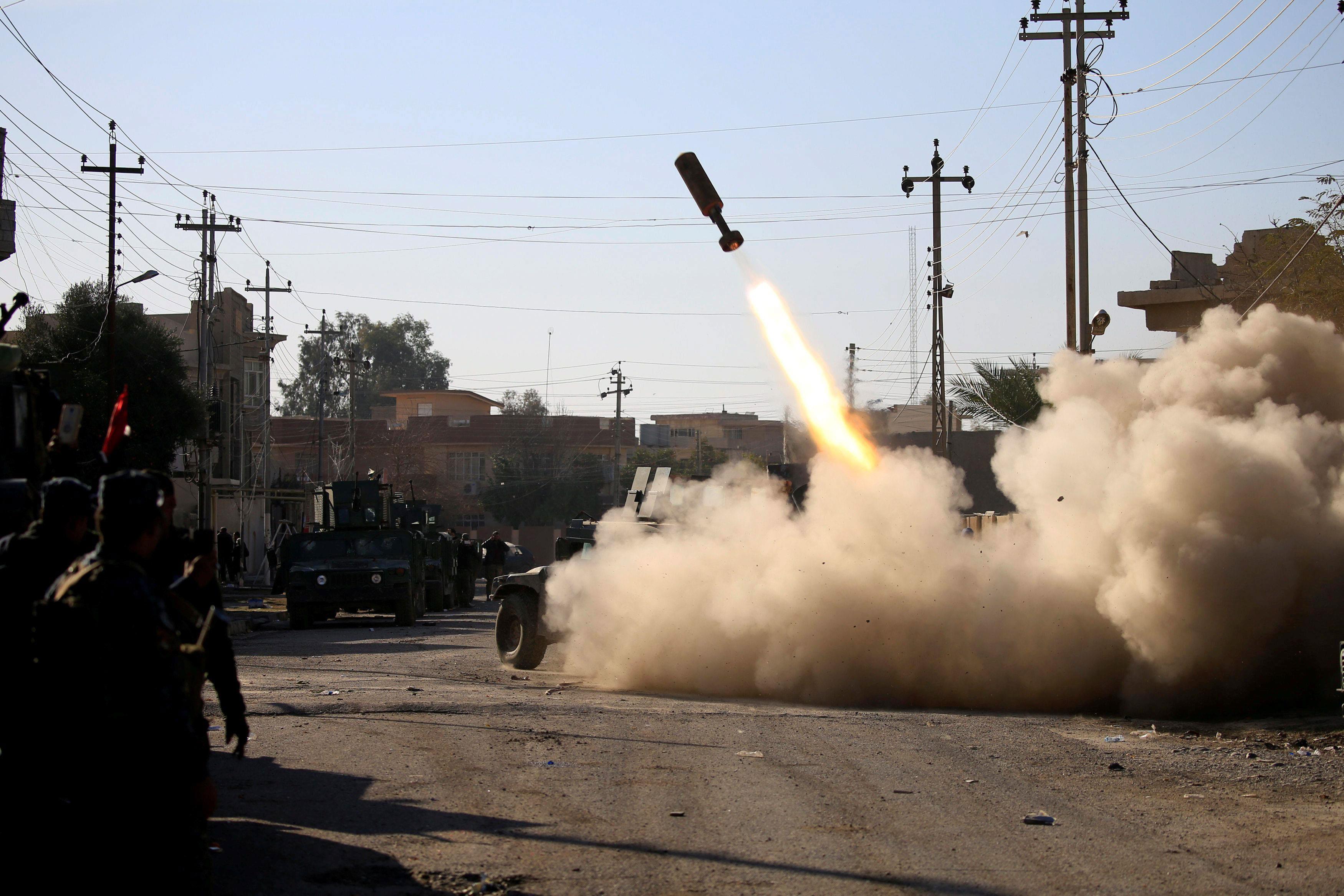 Members of the Iraqi rapid response forces fire missile toward Islamic State militants during a batt