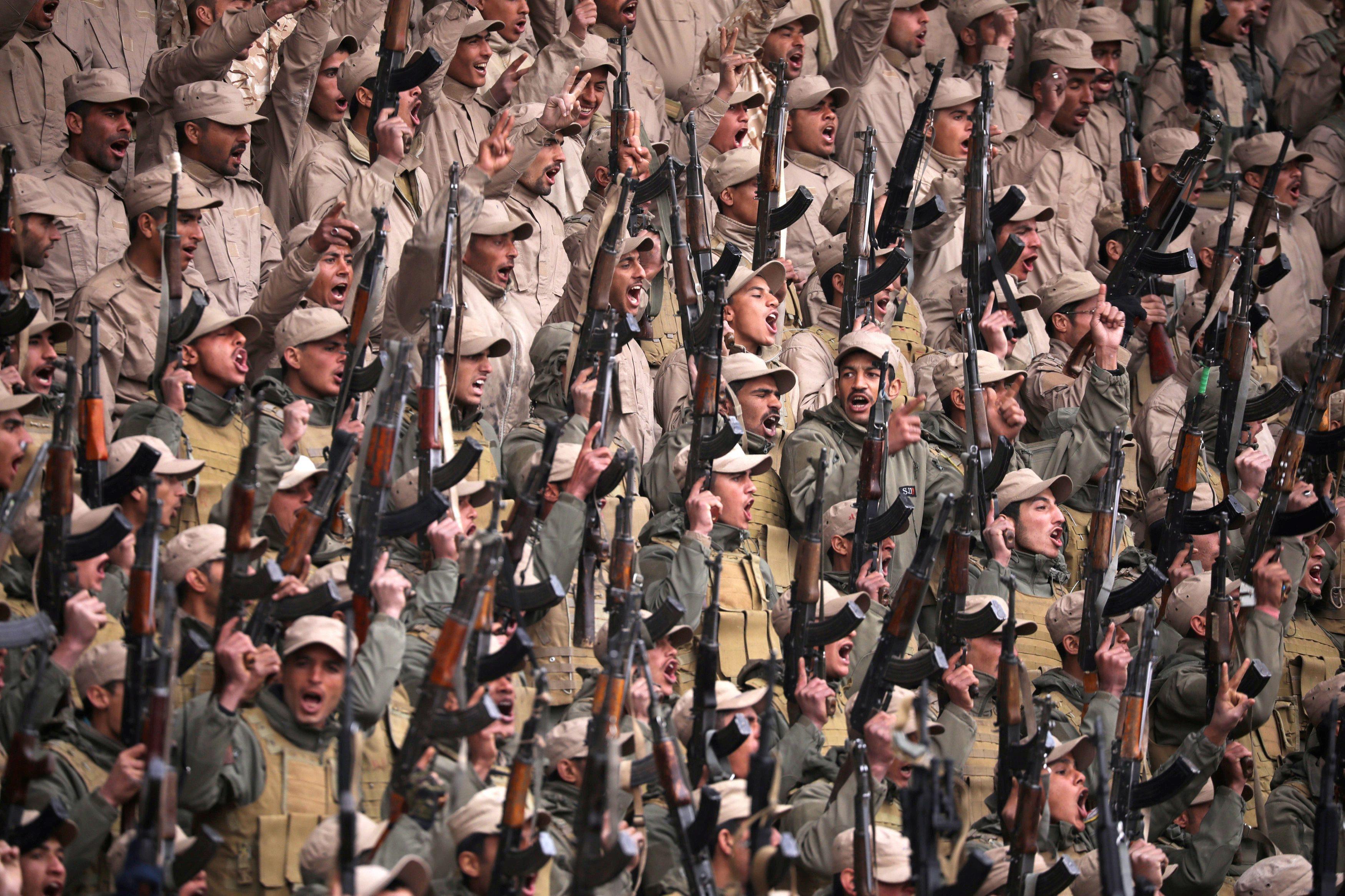 Fighters from the self-defence forces of the Kurdish-led north hold their weapons during a rally in 