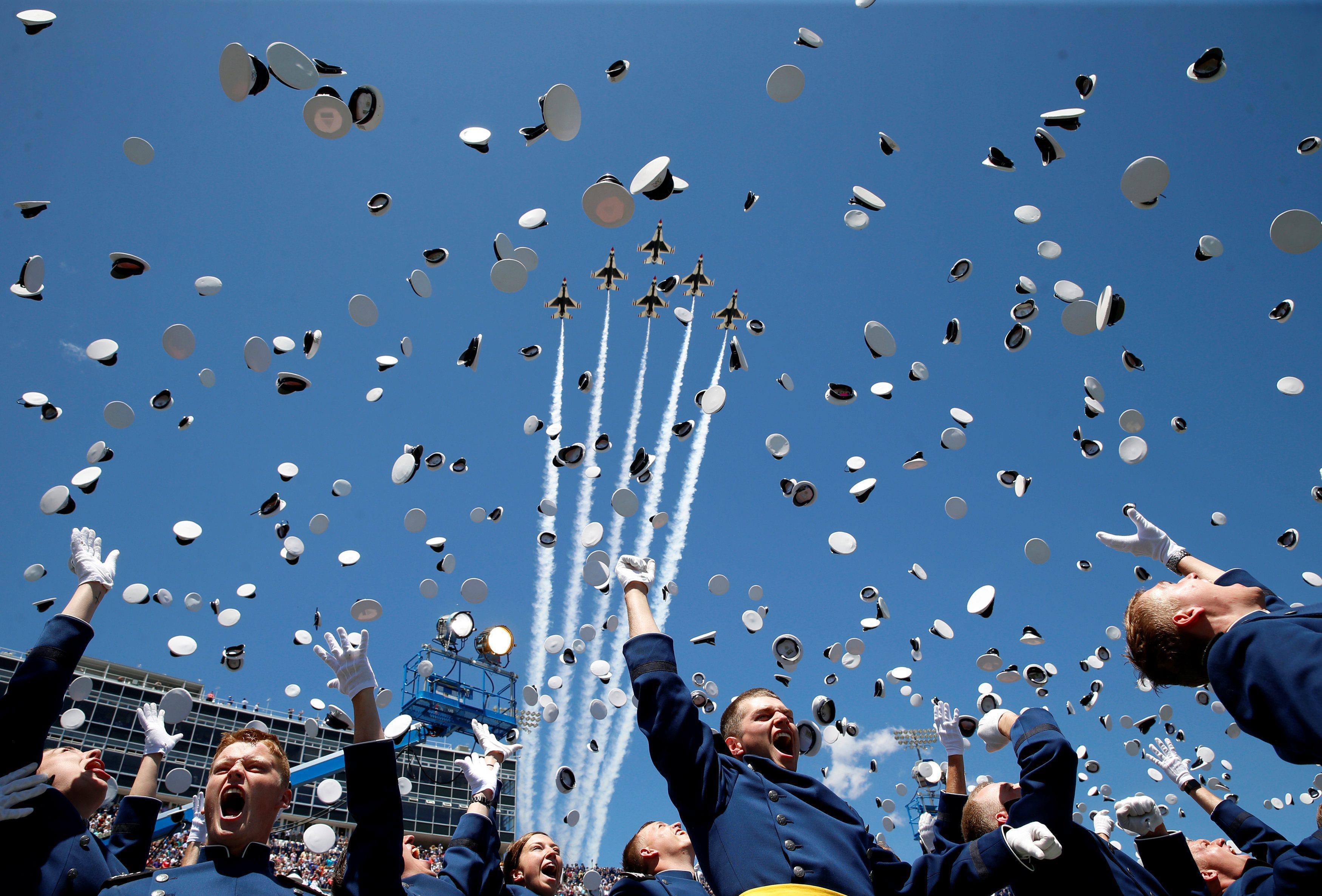 The Thunderbirds perform a fly-over as graduates from the Air Force Academy toss their hats in the a