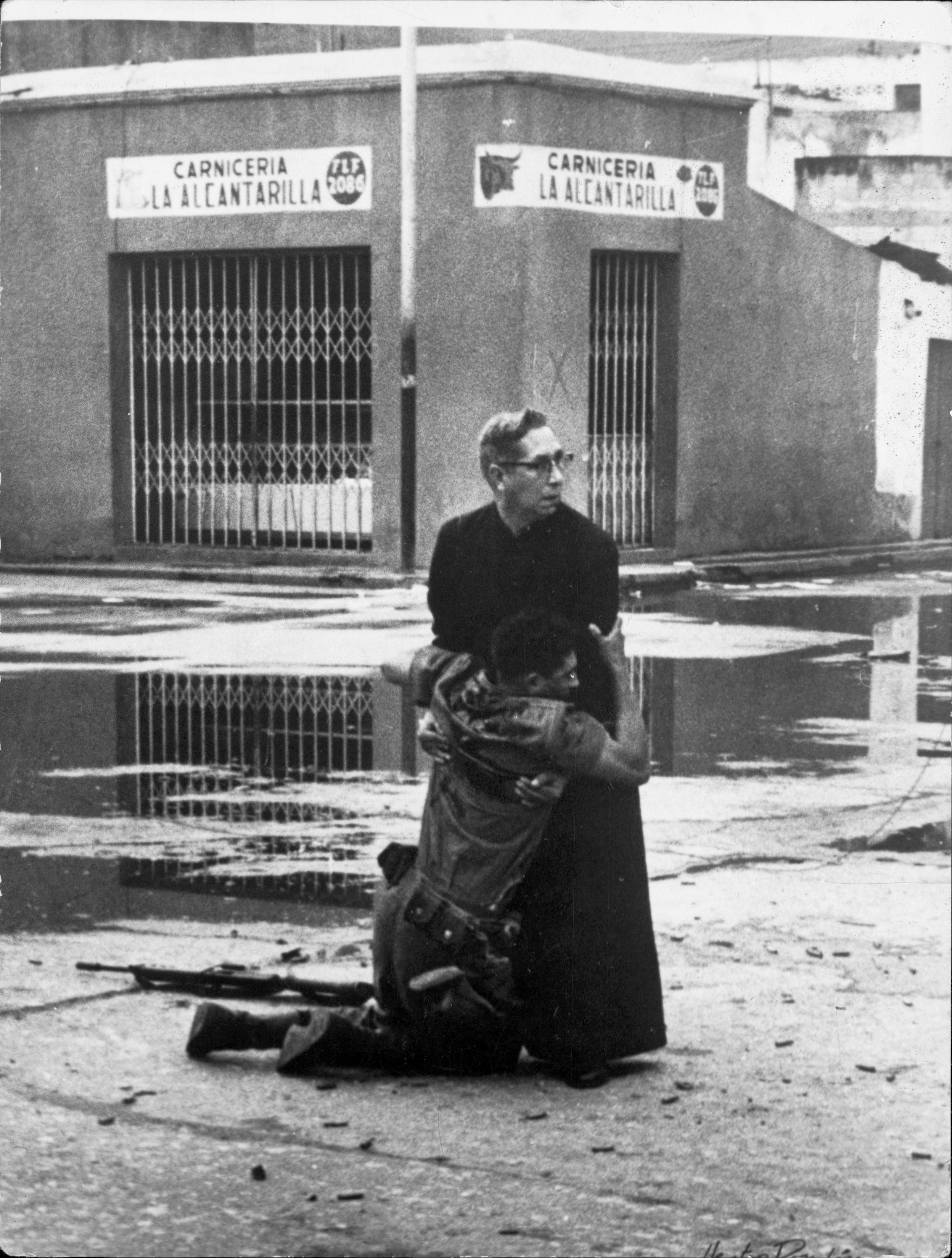 Zdjęcie roku 1962 zostało zrobione w Wenezueli w czasie El Porteñazo - zbrojnej komunistycznej rebelii przeciwko rządowi i prezydentowi Romulo Betancourtowi. W czerwcu w mieście Puerto Cabello batalion wojska wystąpił przeciwko siłom rządowym. W czasie czterech dni walk zginęło około 400 osób, w tym większość buntowników. Był to jeden z ostatnich takich aktów przeprowadzonych przez wenezuelską partię komunistyczną - w 1967 roku ugrupowanie zdecydowało się odrzucić walkę zbrojną jako środek dojścia do władzy i wystartowało w wyborach. Na zdjęciu widać śmiertelnie rannego żołnierza sił rządowych, podtrzymywanego przez ojca Luisa Manuela Padillę. Wokół trwał ostrzał snajperów. Poza tytułem zdjęcia roku, fotografia została wyróżniona Nagrodą Pulitzera. Wojna i śmierć na stałe weszła do kanonu tematów zdjęć prezentowanych w czasie konkursu. / autor: Héctor Rondón Lovera / dziennik