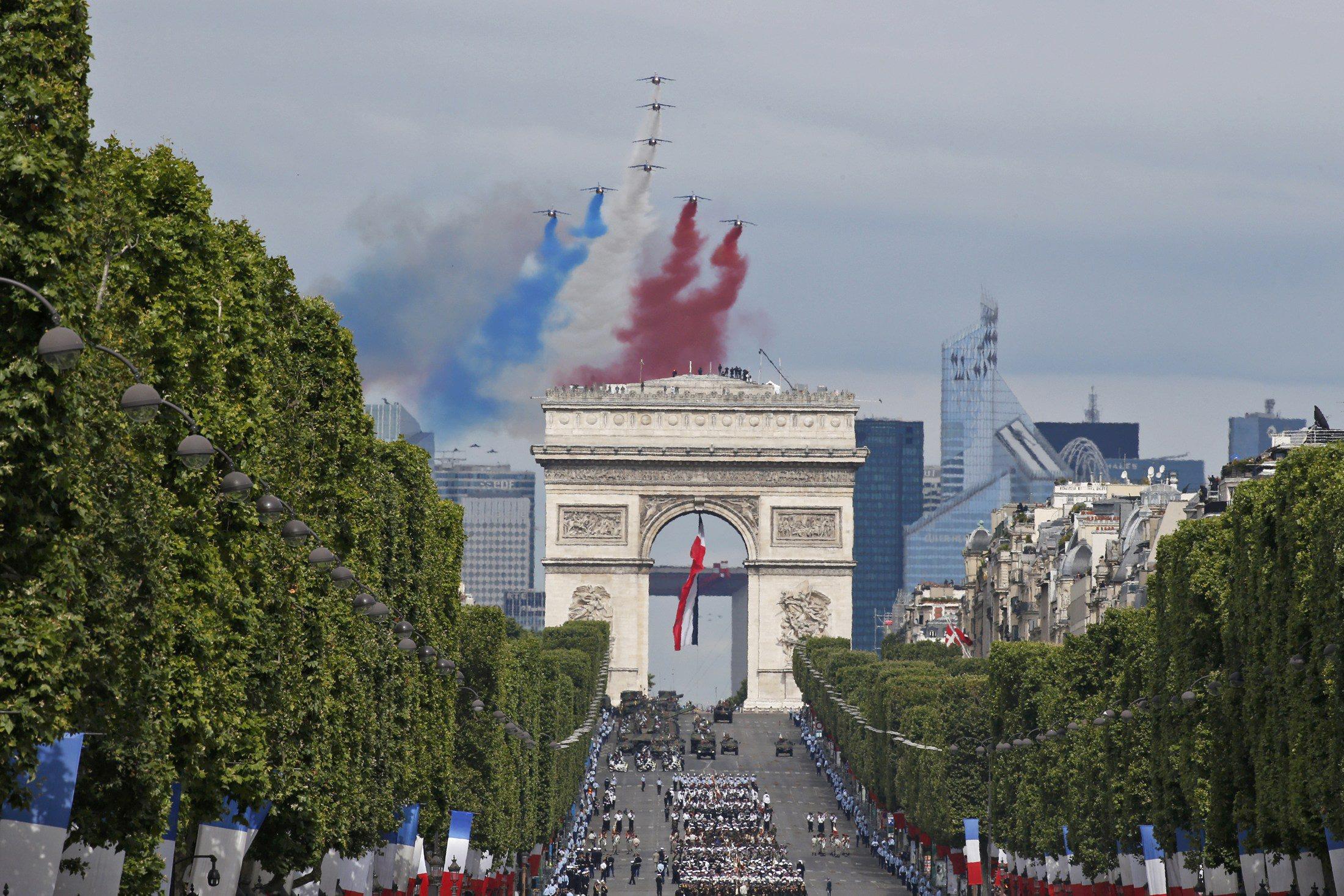 Alpha jets from the Patrouille de France fly in an 'Eiffel Tower' formation over the Champs-Elysees 