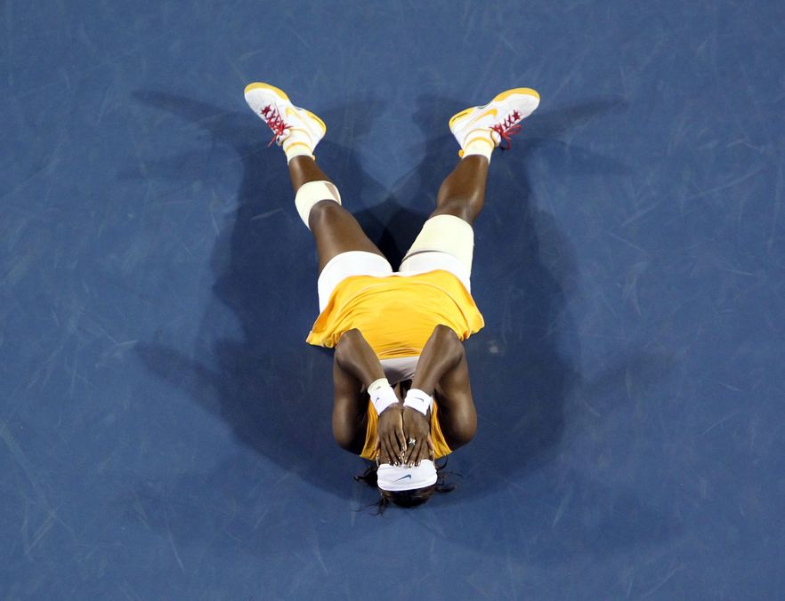 Serena Williams leży na korcie po zwycięstwie w finale Australian Open nad Belgijką Justine Henin
