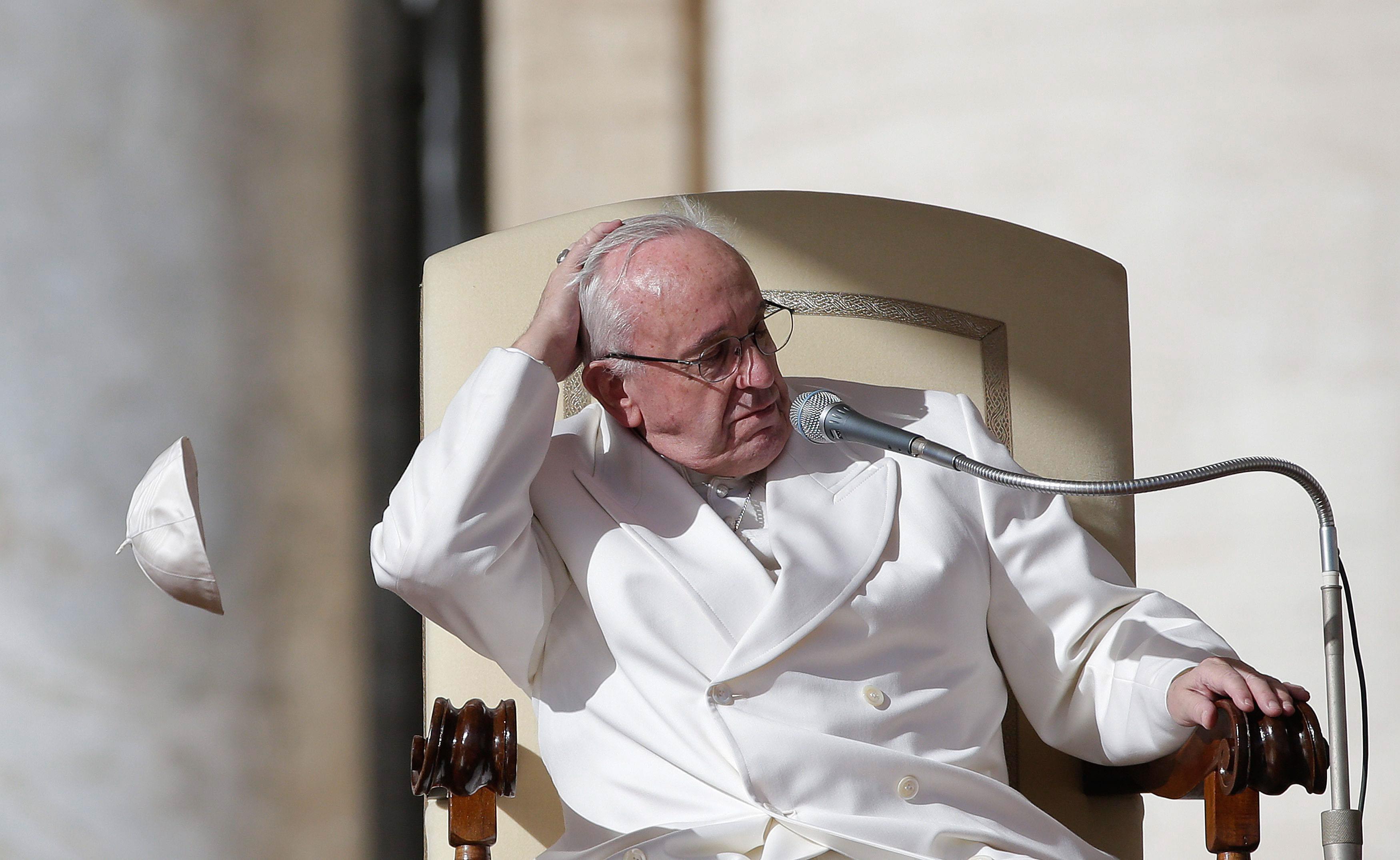 A gust of wind blows away Pope Francis' skullcap during his weekly general audience in Saint Peter's