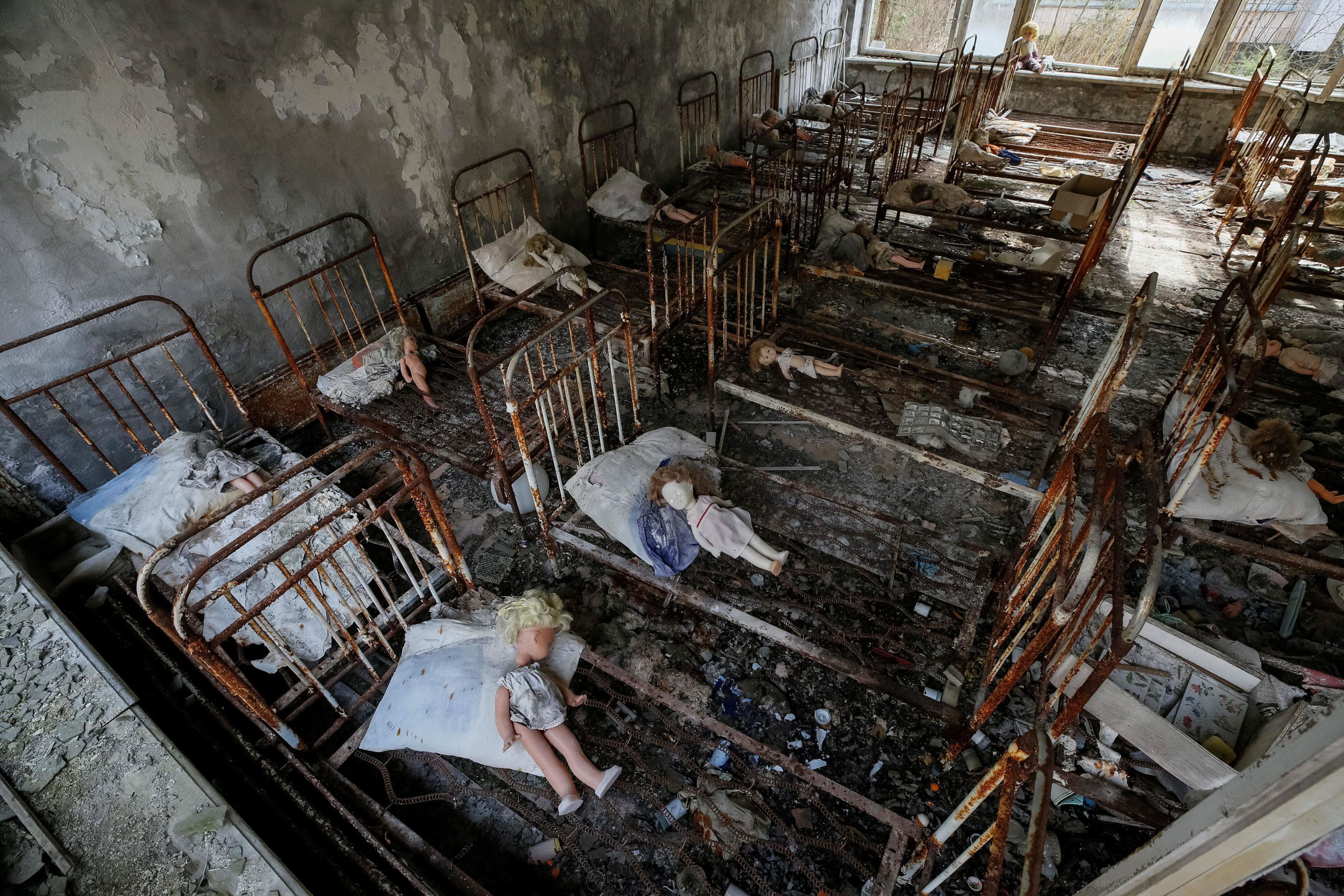 Dolls, which were placed by a visitor, lie at beds at a kindergarten in the abandoned city of Pripya