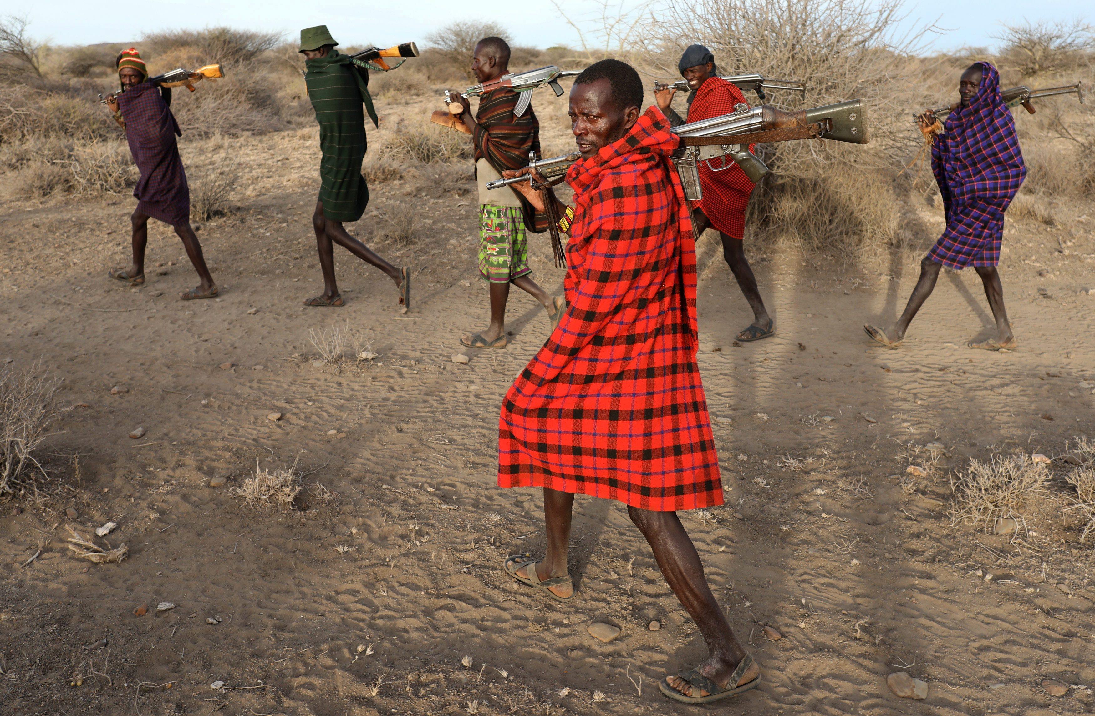 Turkana tribesmen walk with guns in order to protect their cattle from rival Pokot and Samburu tribe