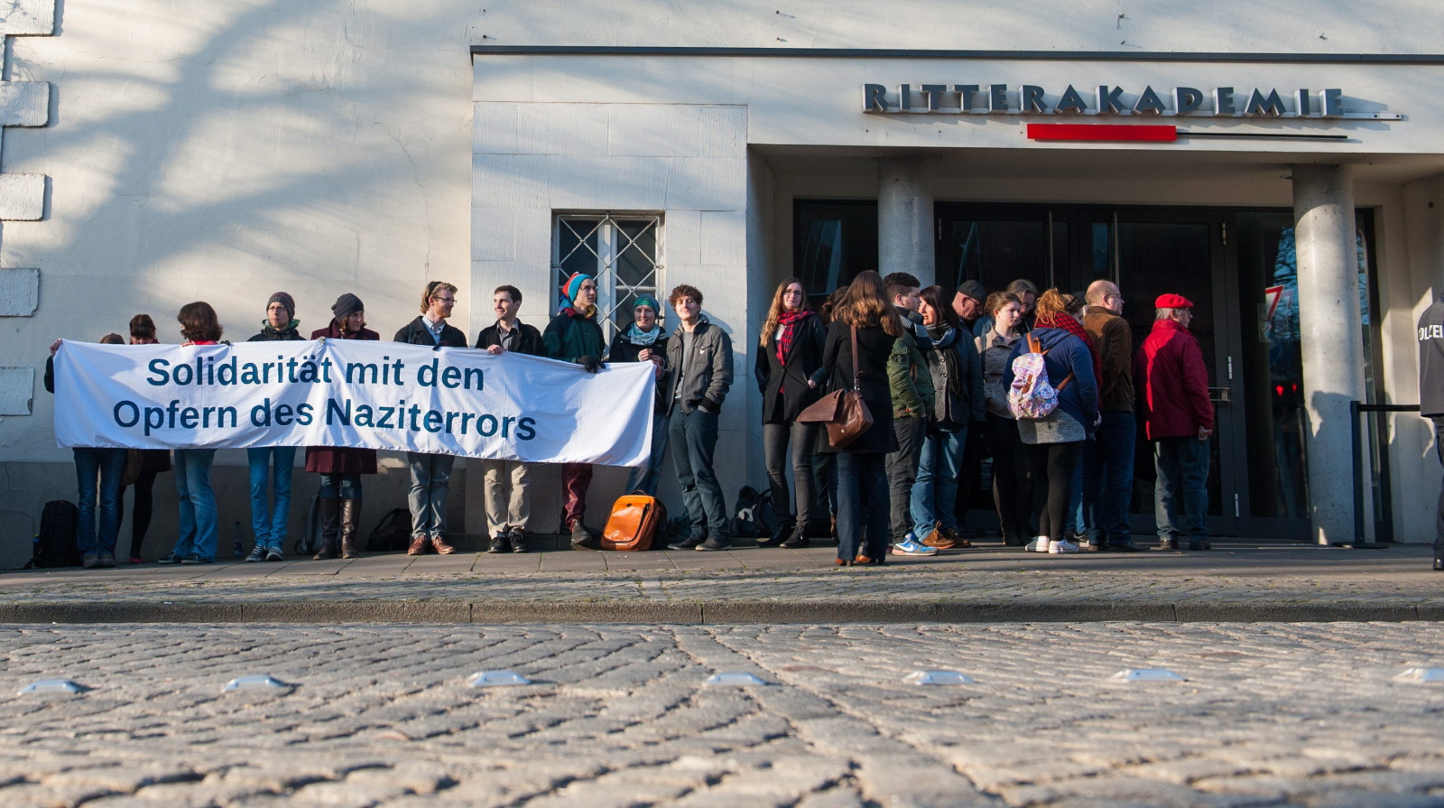 Demonstracja przed sądem, w którym odbywa się proces Oskara Groeninga. Napis na transparencie: Solidarność z ofiarami nazistowskiego terroru
