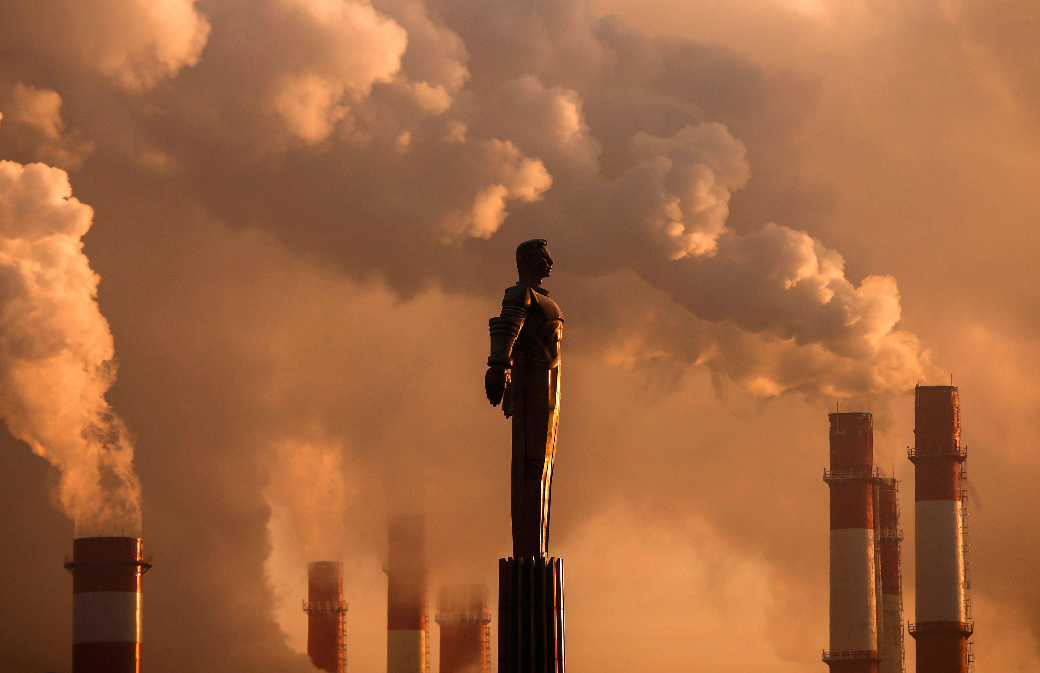 Steam rises from chimneys of a heating power plant near a monument of Soviet cosmonaut Yuri Gagarin 