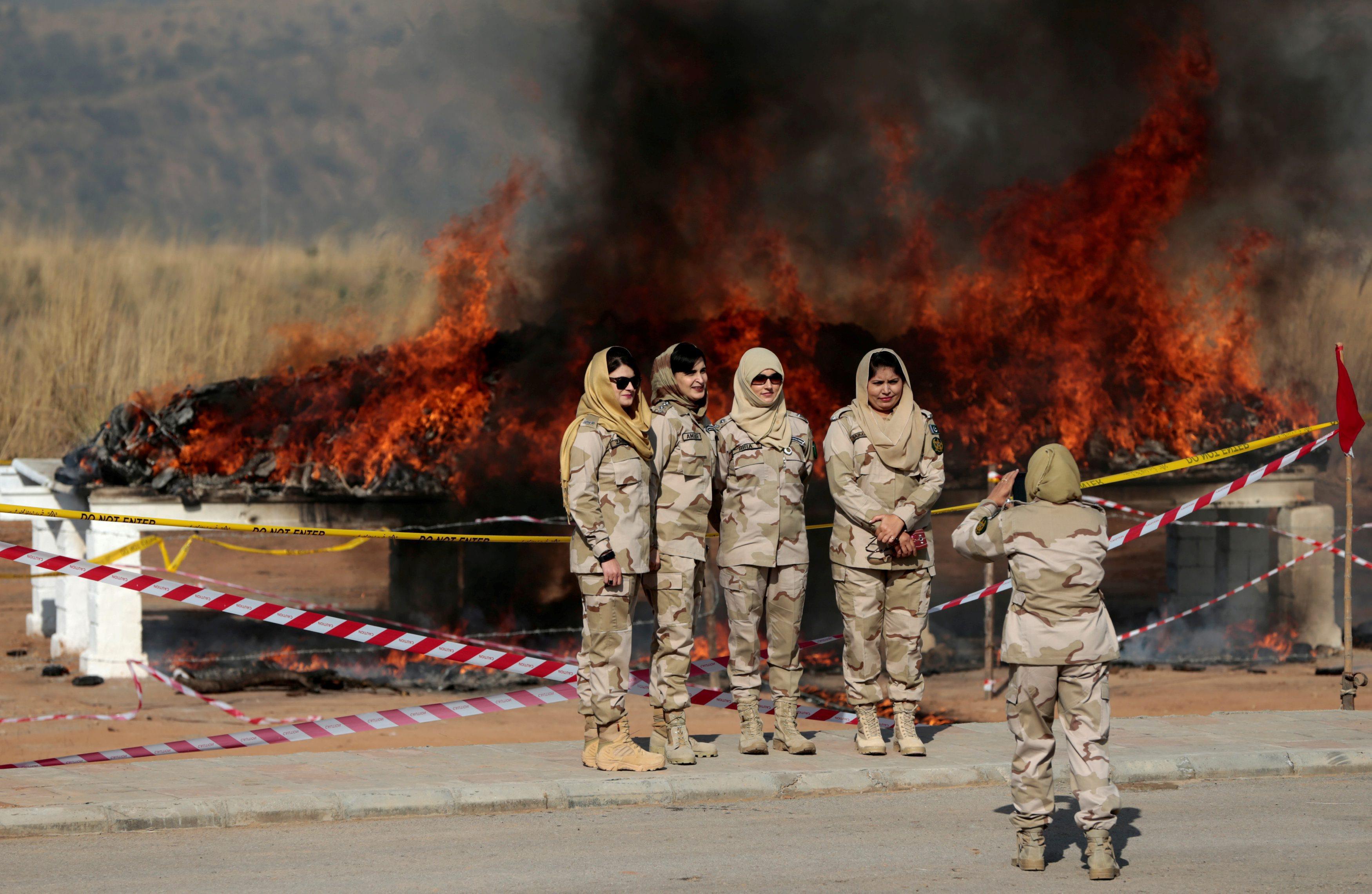 Members of the anti narcotics force pose for a picture as drugs are burned during a ceremony in Isla