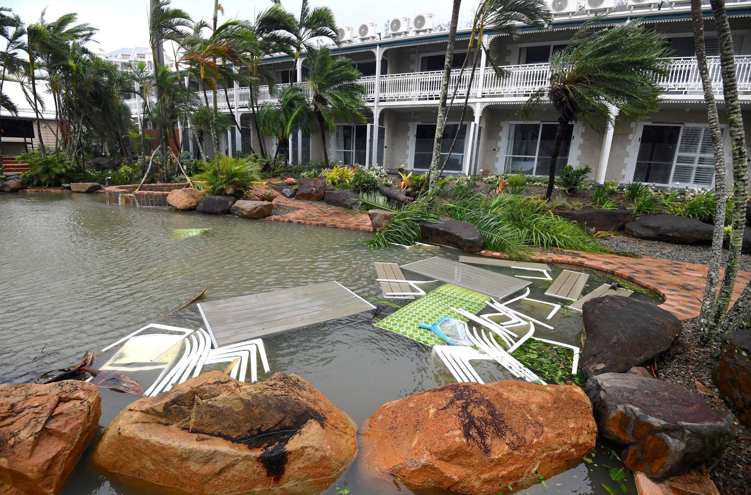 Outdoor furniture lies in a pool at a motel as Cyclone Debbie hits the northern Queensland town of A