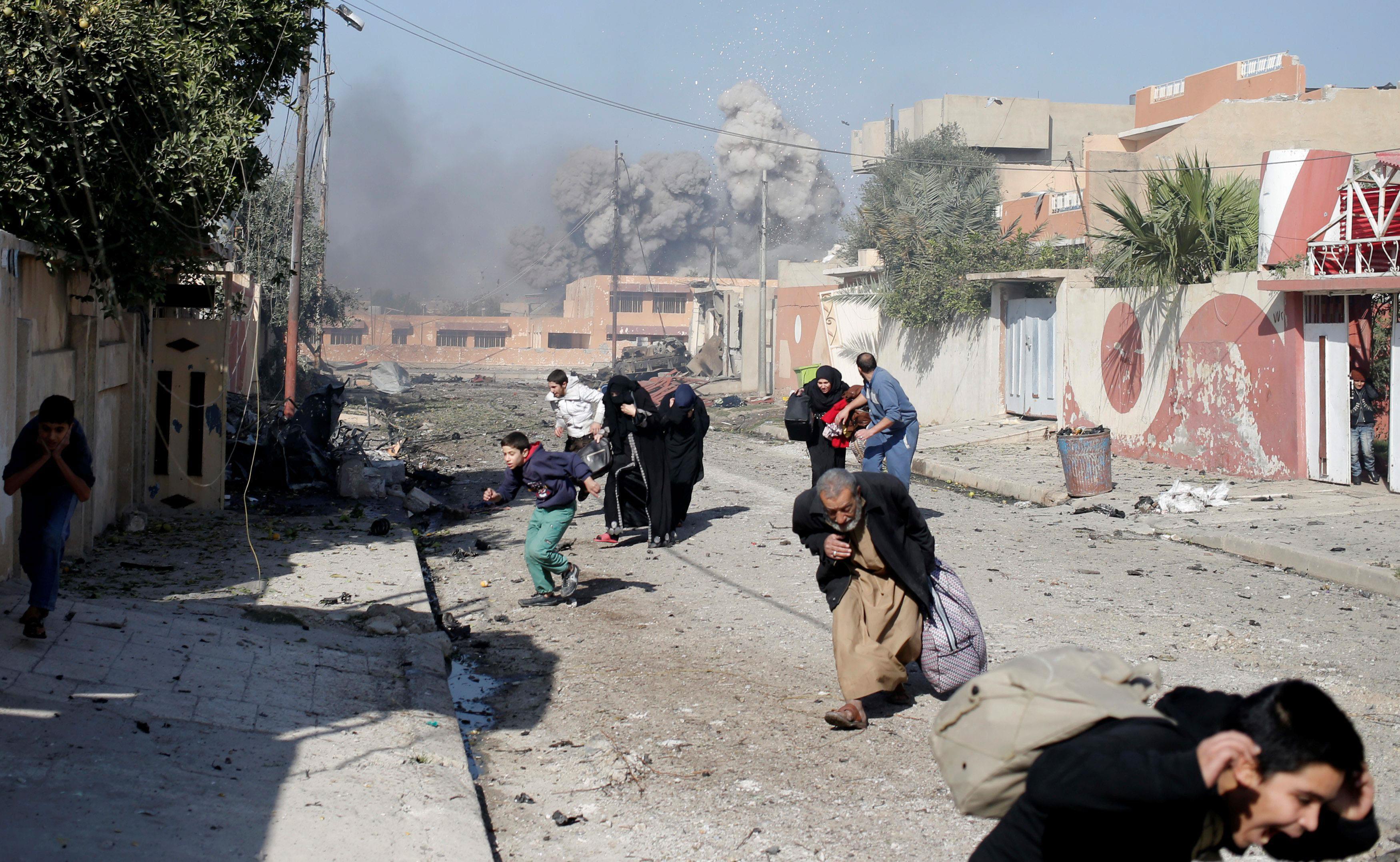 People run in panic after a coalition airstrike hit Islamic State fighters positions in Tahrir neigh