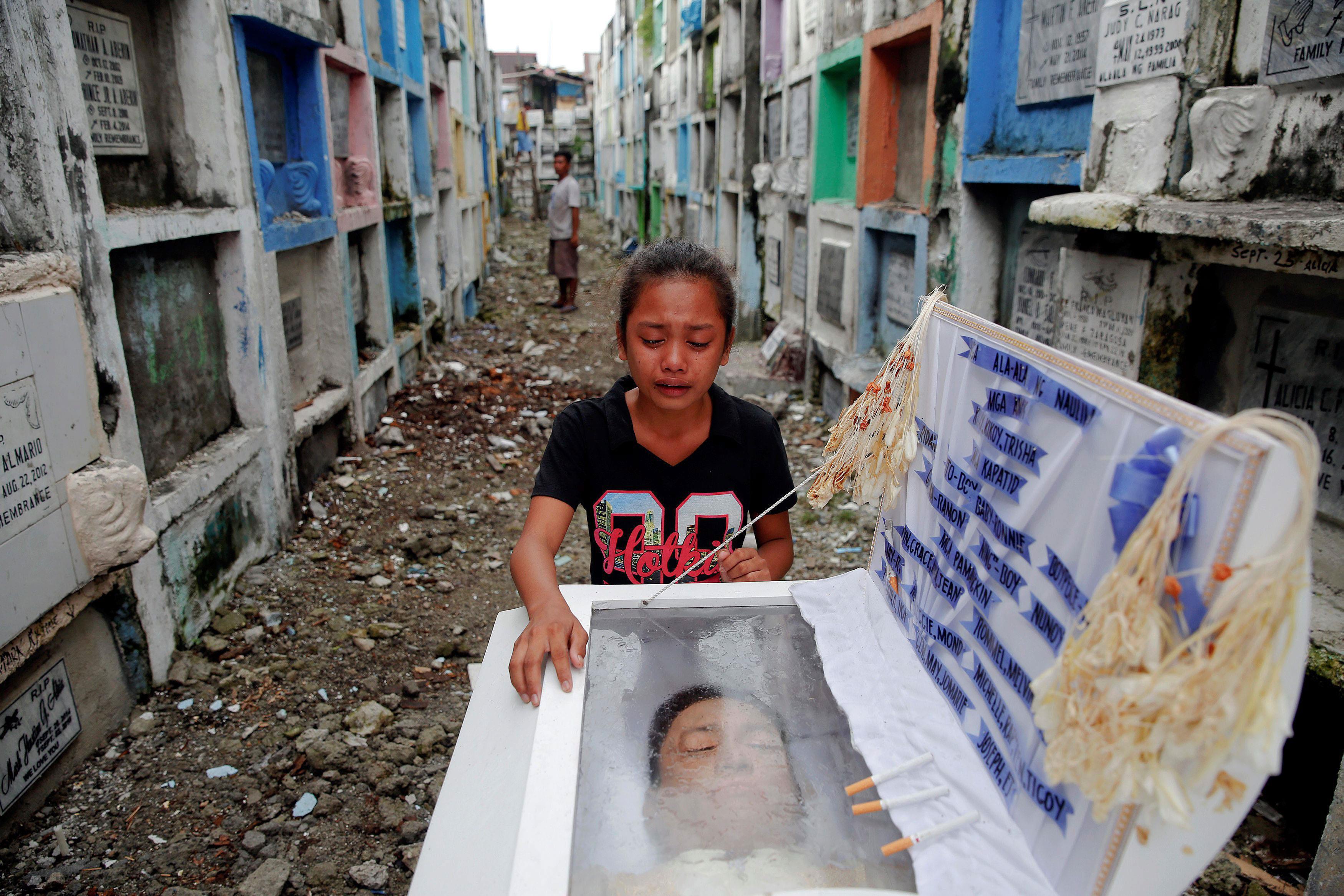 Kasandra Kate, 12, cries over the open coffin of her father Verigilio Mirano during his funeral at N