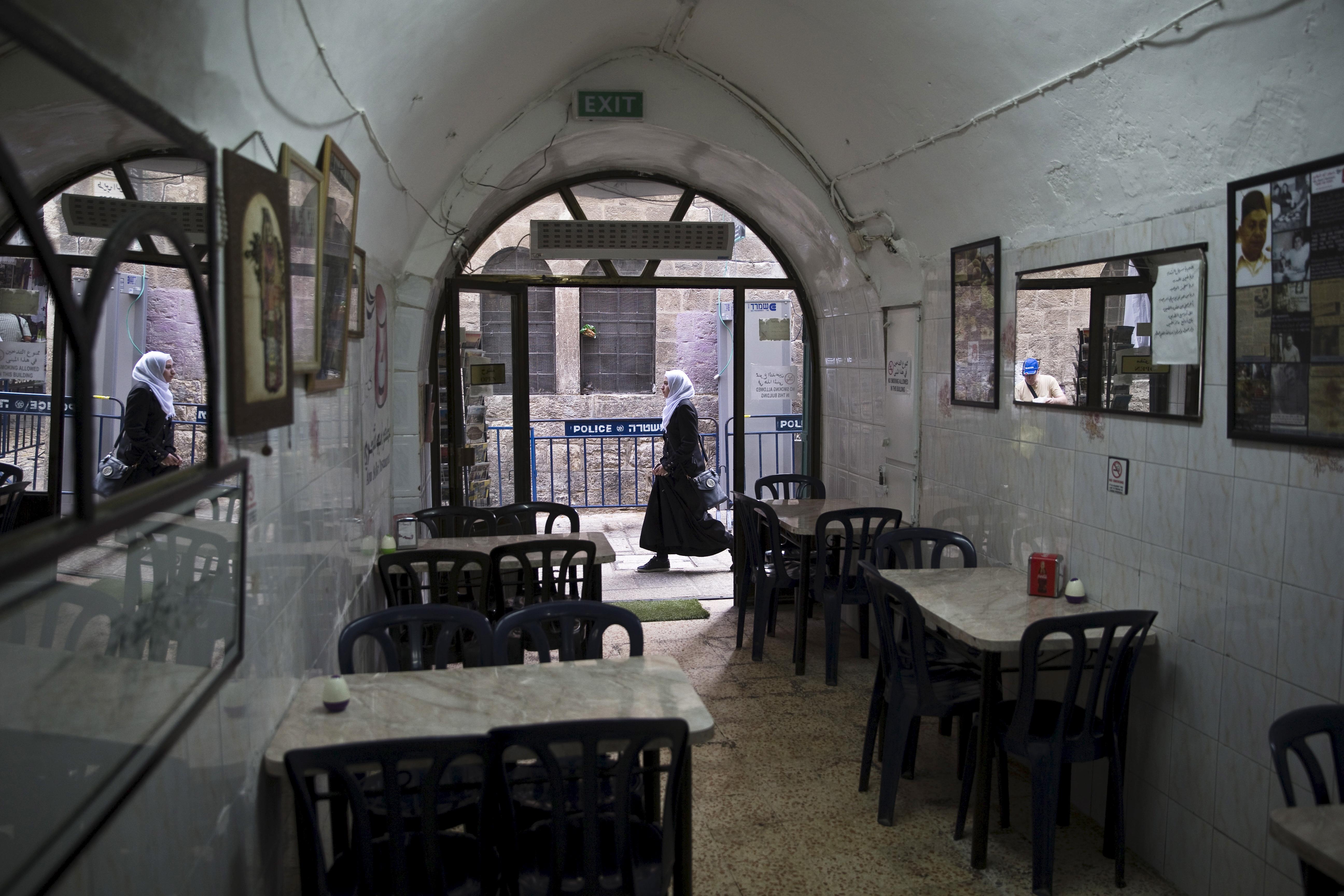 A Palestinian woman walks past Abu Shukri's hummus restaurant in Jerusalem's Old City 
