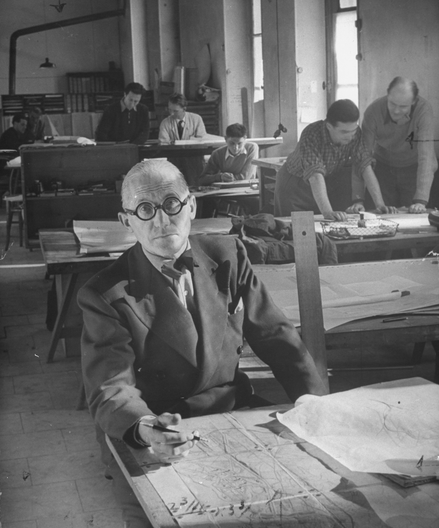 Le Corbusier w swoim paryskim atelier. Jerzy Sołtan w prawym górnym rogu, nachyla się nad projektem z kolegą, maj 1946 r.
